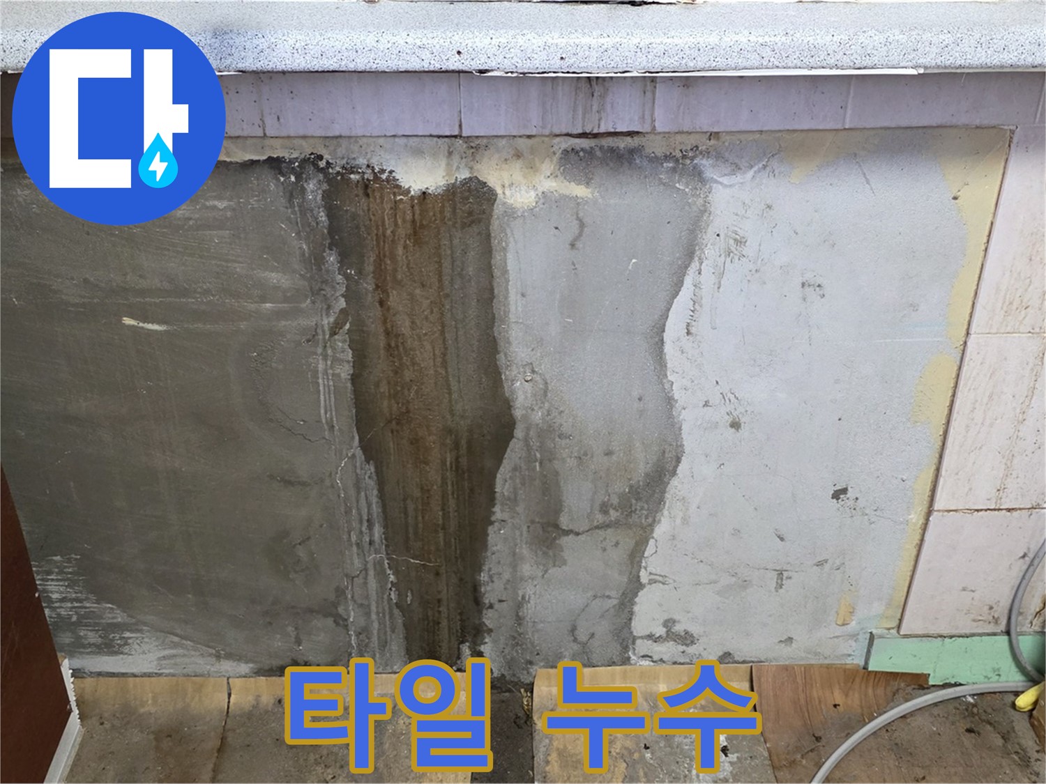 싱크대 옆 타일 누수 - 젖은 타일과 누수 흔적을 보여줍니다.
