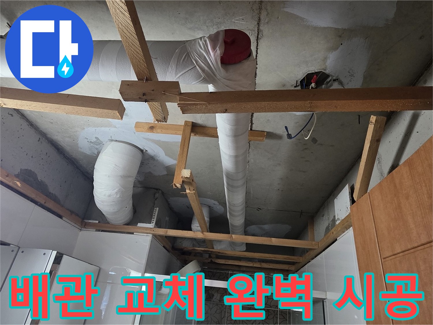 화장실 천장-흰색 PVC 배관과 목재 지지대가 보이는 현장 사진