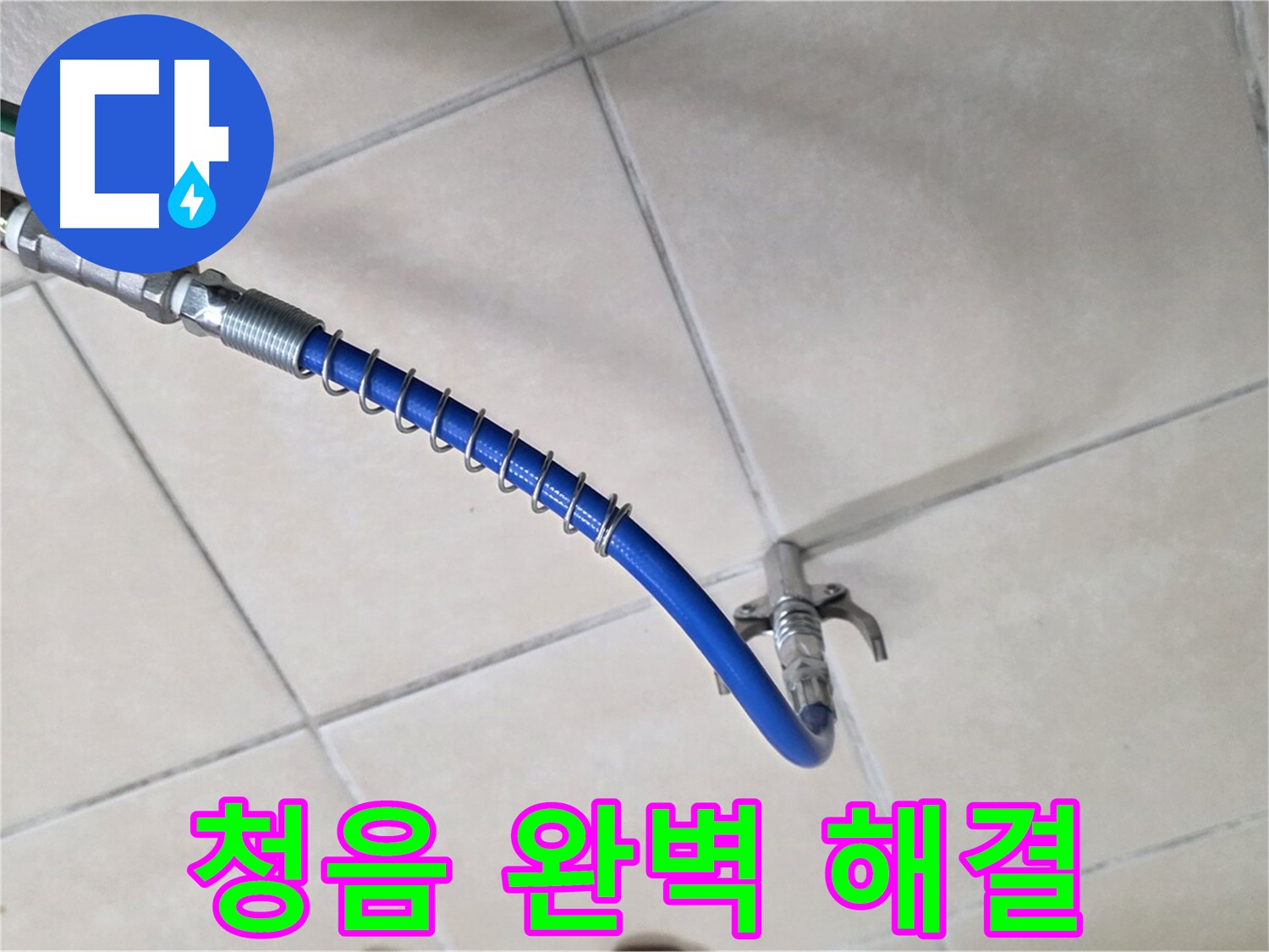 바닥 타일 위에 놓인 파란색 고압 호스와 연결 부속 장치