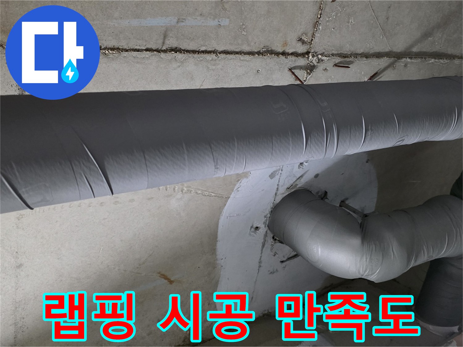 회색 단열재로 감싸진 천장 내부의 배관 연결 부위입니다.