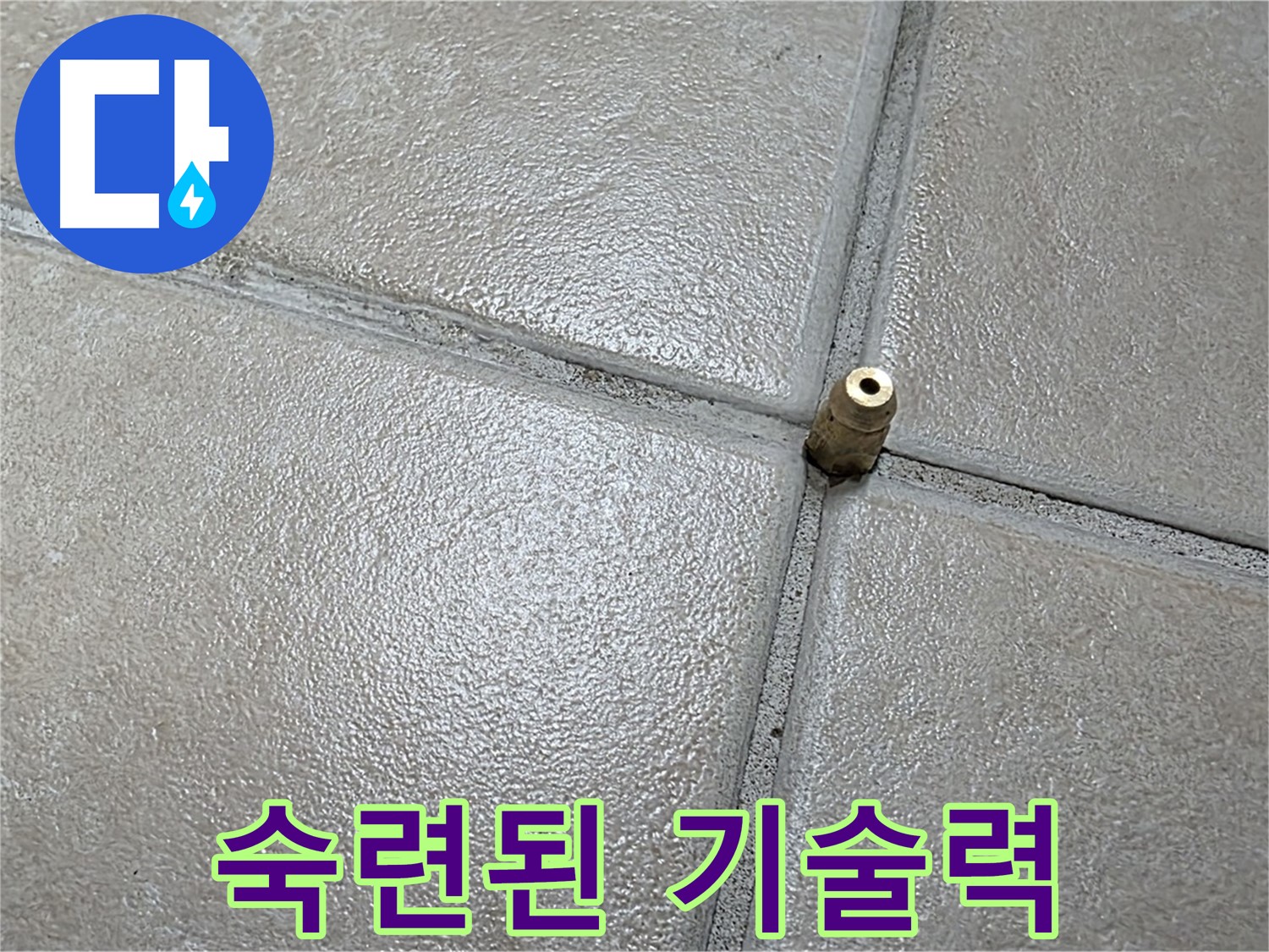 회색 타일 바닥 줄눈에 위치한 금속 배관 소켓