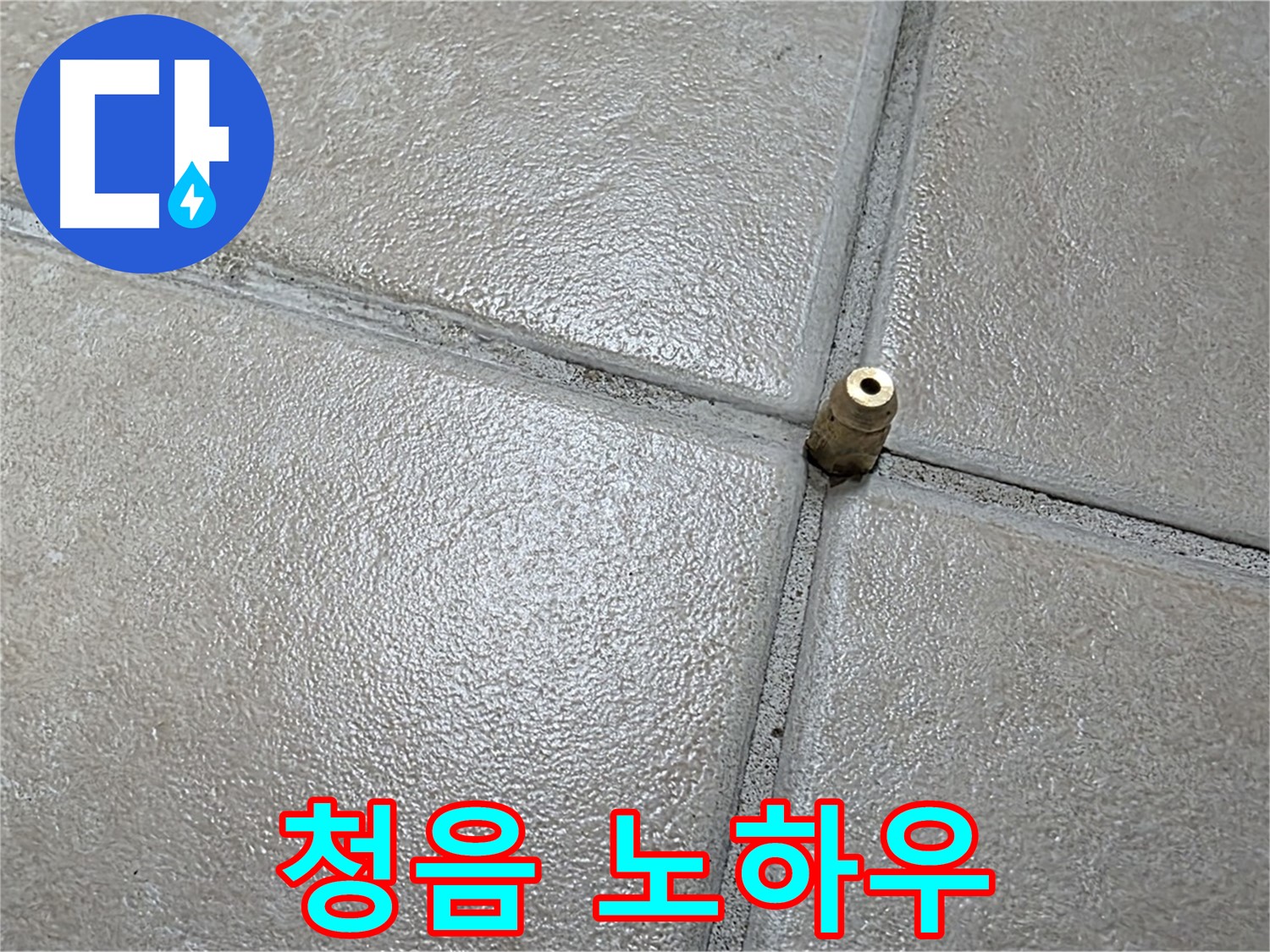 회색 욕실 타일 바닥에 위치한 금속 배관 소켓