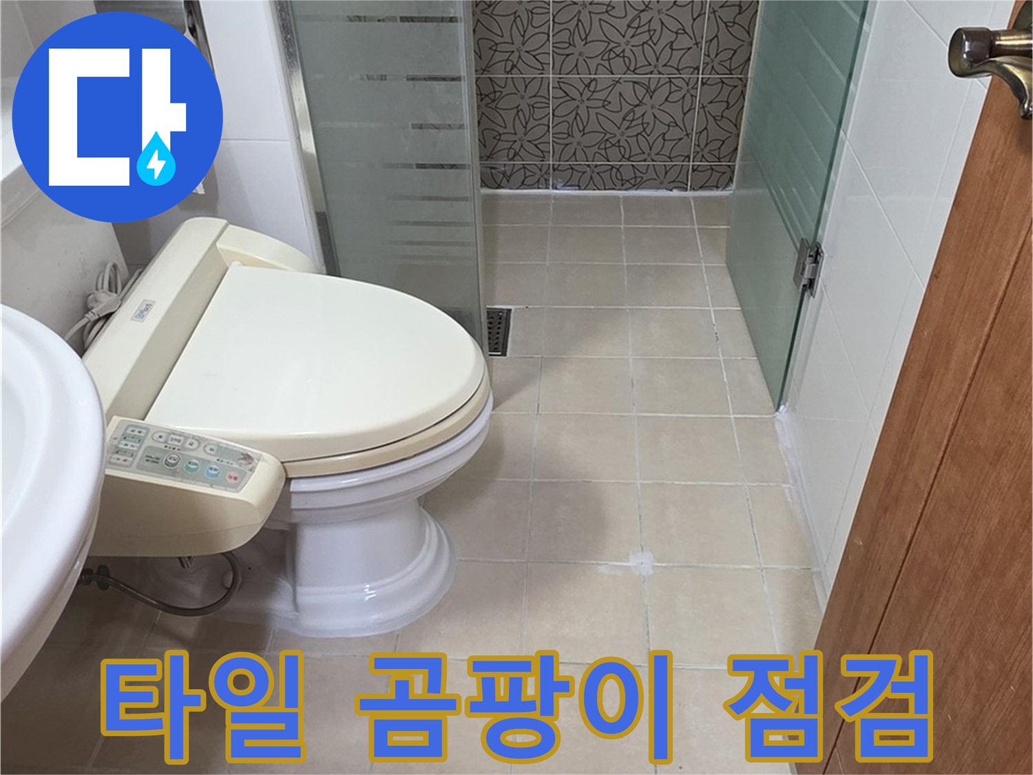 베이지색 타일로 마감된 욕실 벽면과 유리 칸막이입니다.