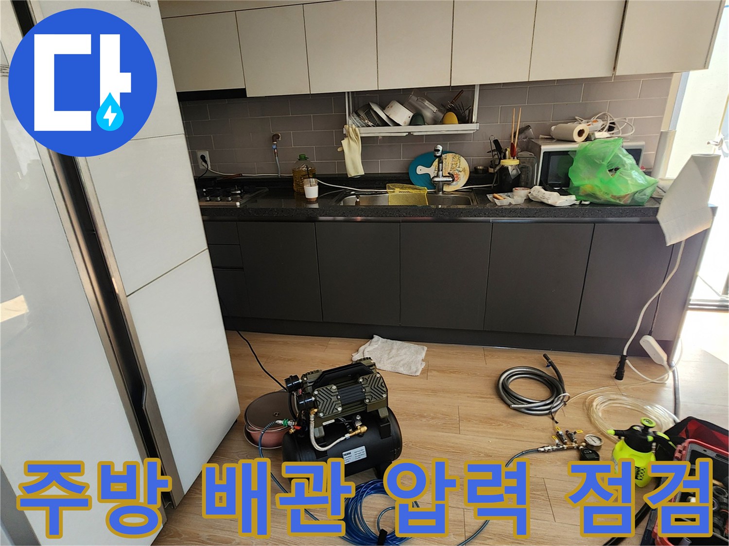 주방 싱크대 바닥에 설치된 공압 테스트용 에어 컴프레서와 연결 호스