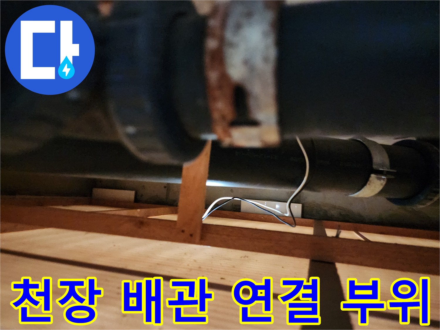 주방 천장 내부의 검은색 배관과 금속 연결 부위 상세 사진
