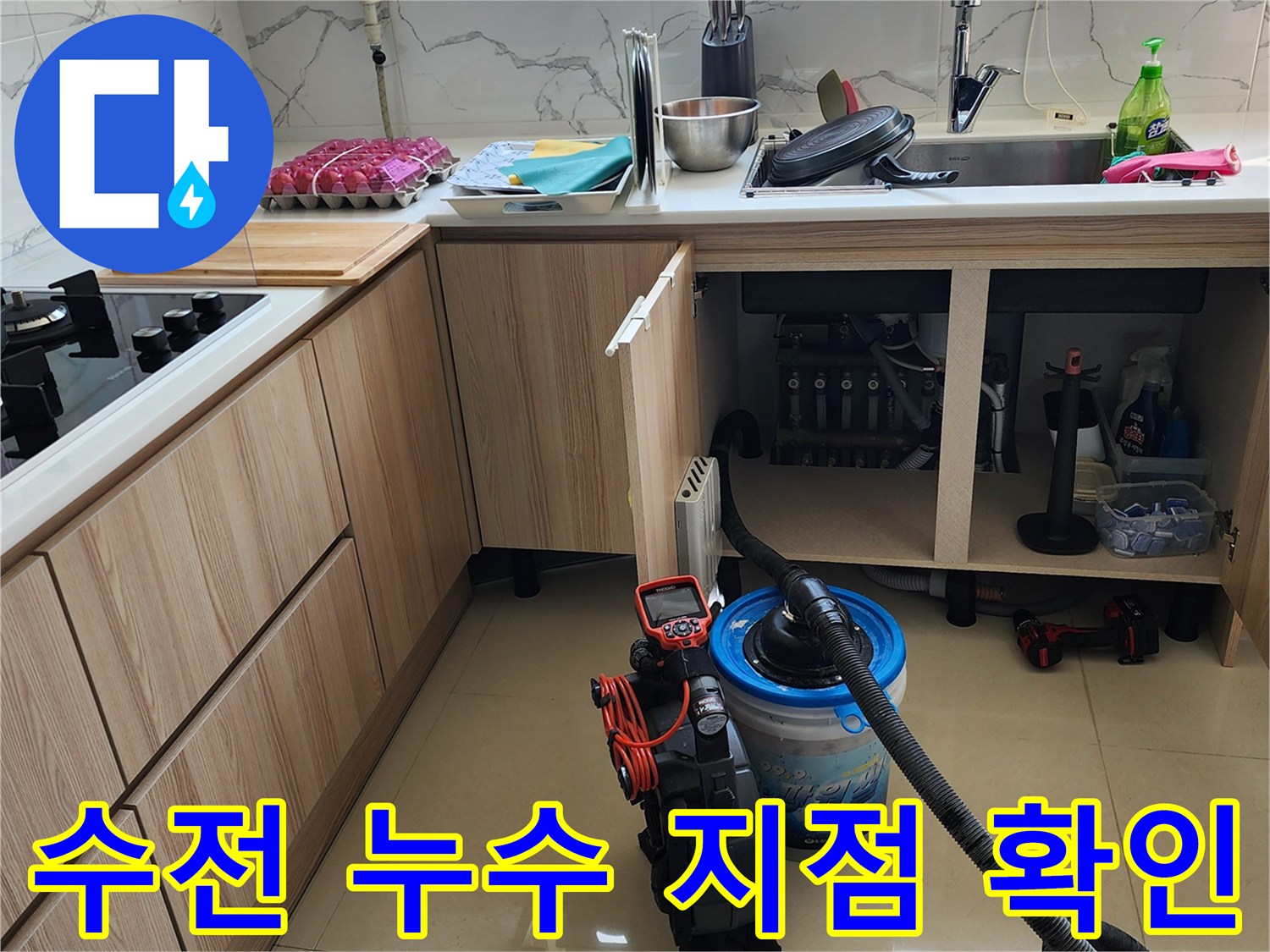 싱크대 수전 연결 부위의 물샘 증상을 확인하기 위해 내부를 조사 중입니다.