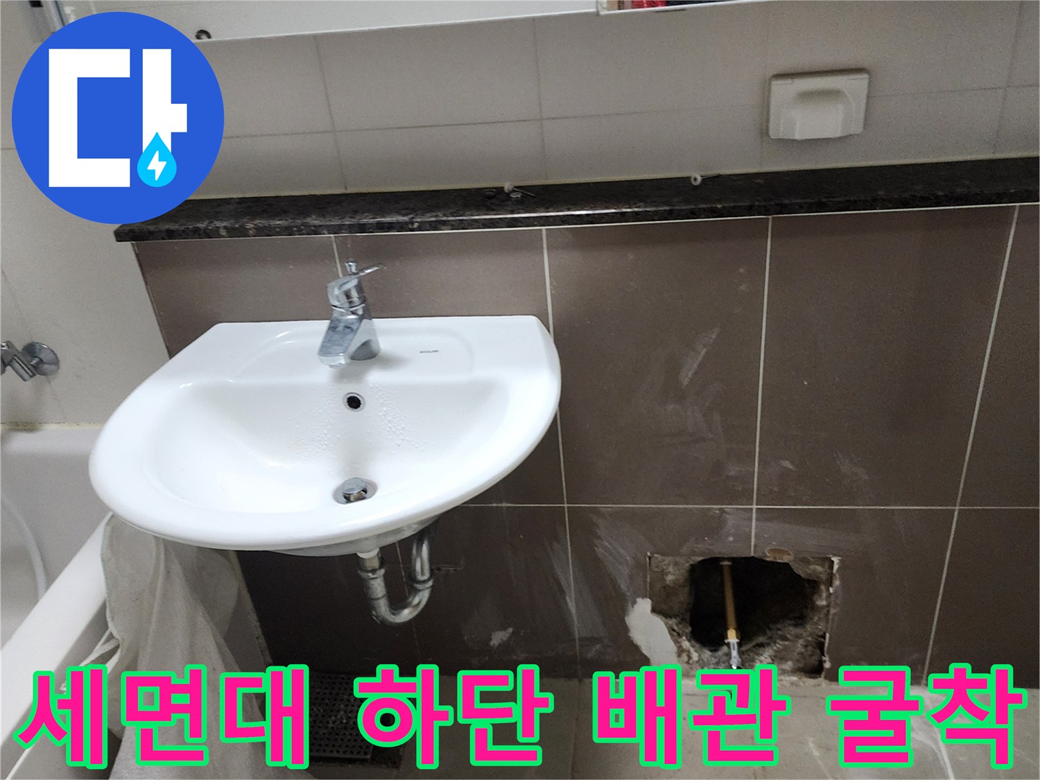 세면대 아래 벽면 타일을 제거하여 드러난 노출 배관의 상태