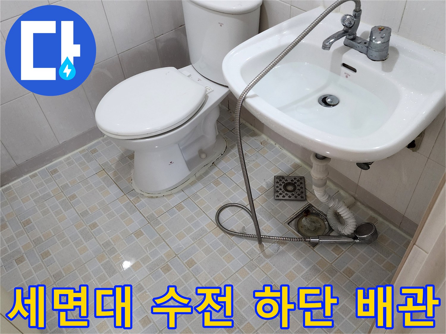 세면대 밑으로 연결된 급수 호스와 하부 배수 부속