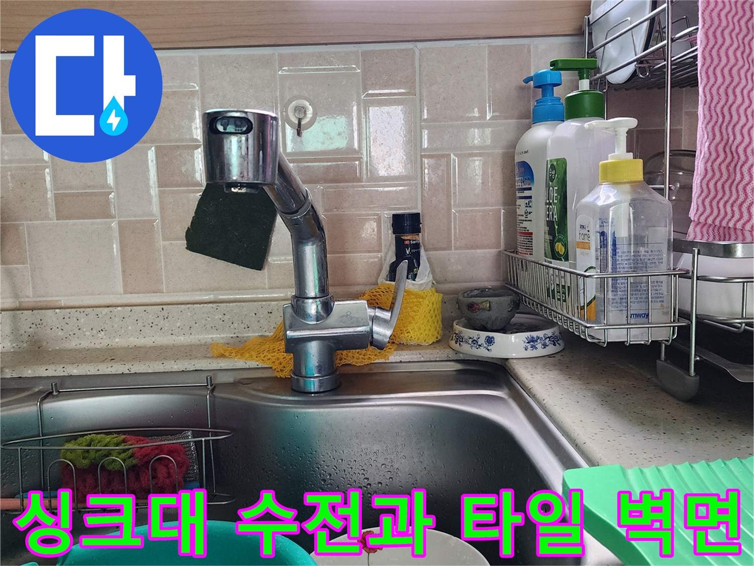 싱크대 수전 부근의 타일 벽면 및 배수 공간 사진입니다.