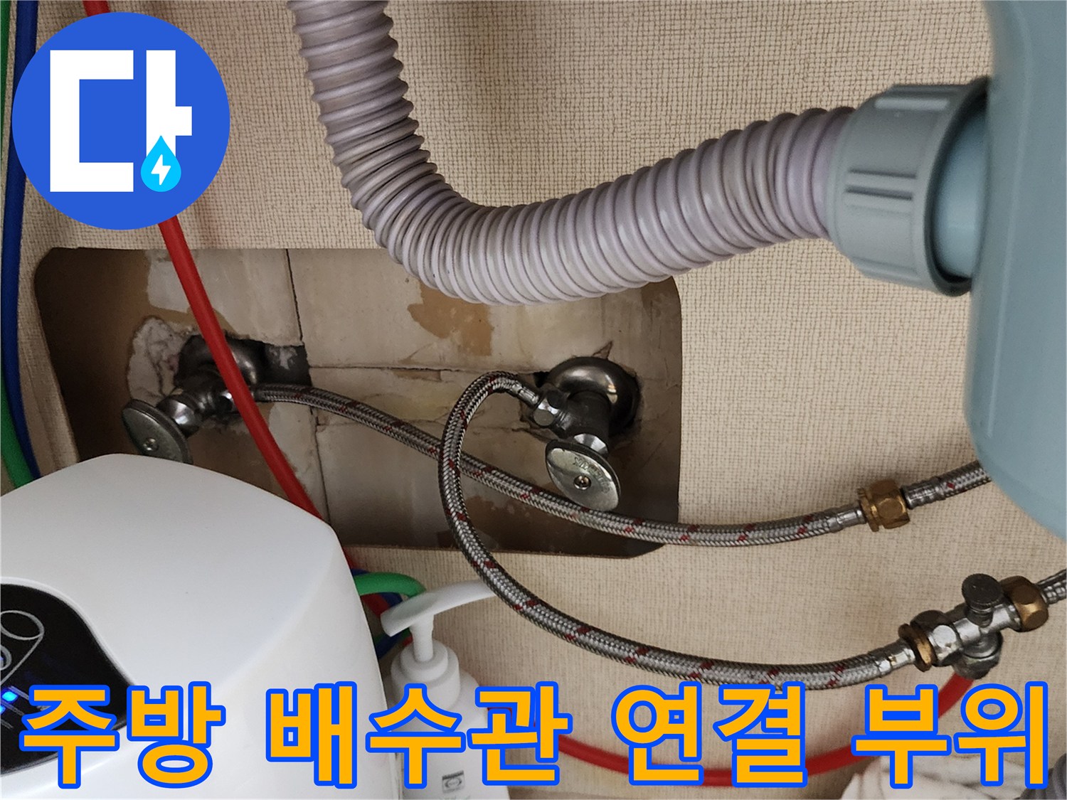 싱크대 아래 벽면 밸브와 배수 호스 사이의 누수 흔적 점검 중입니다.