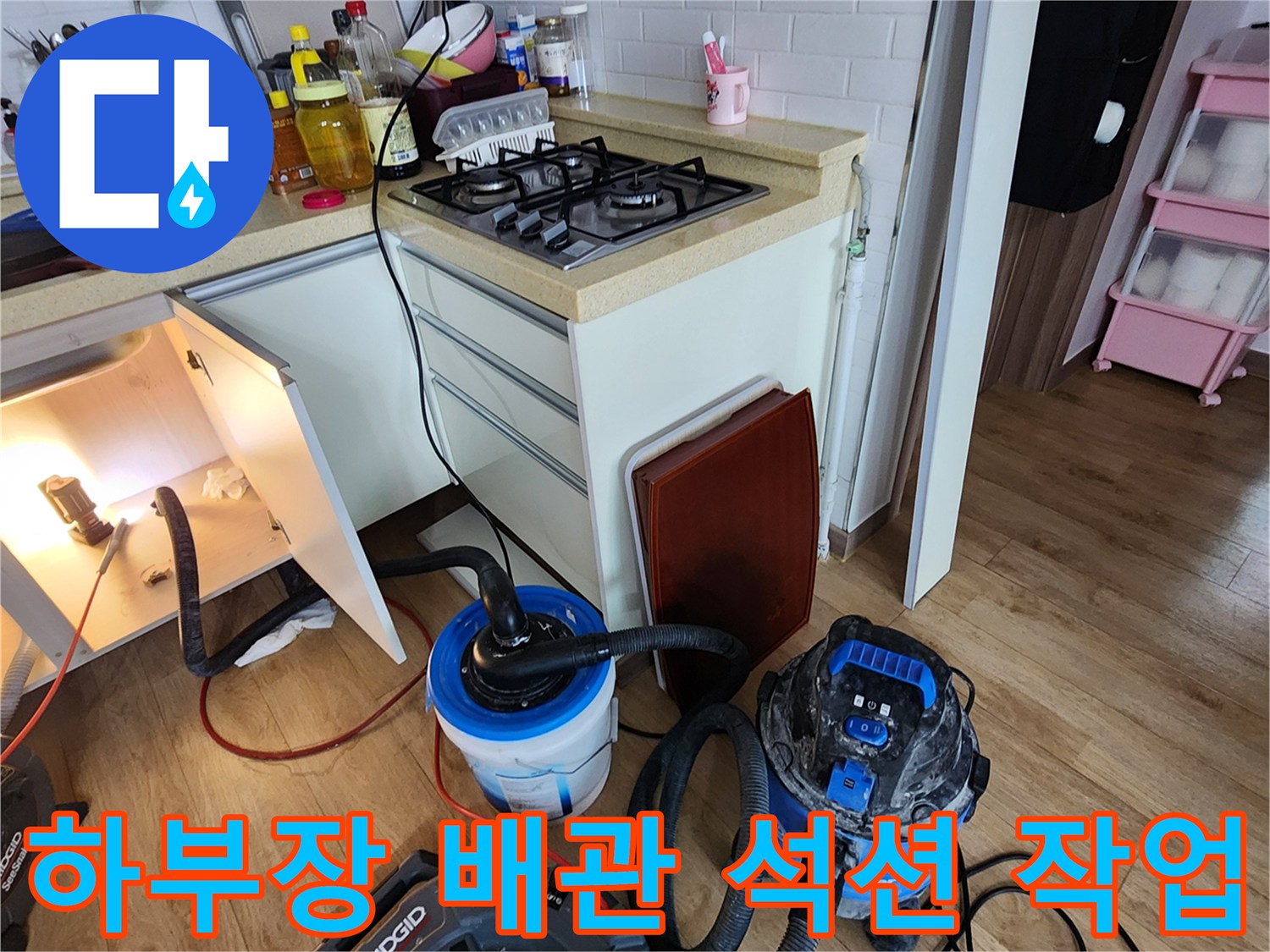 싱크대 밑-배관 청소를 위해 설치된 강력 흡입 장비와 호스 연결 상태