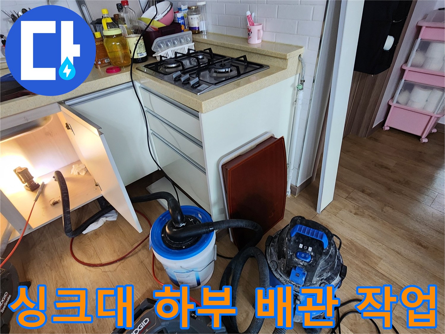 양주 옥정동-주방 싱크대 하부장 내부의 배관 청소 장비 세팅 모습