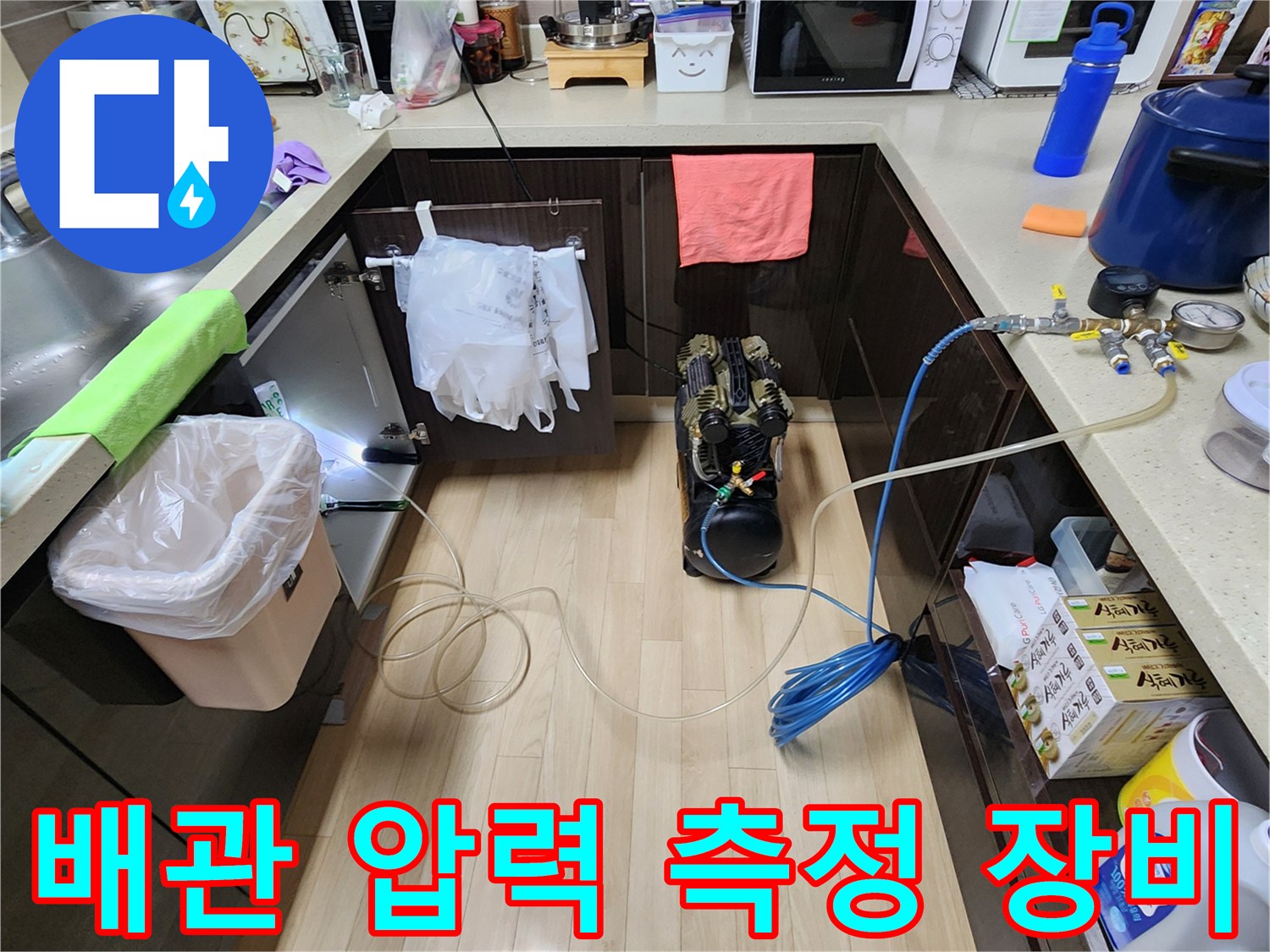 싱크대 밑 배관에 연결된 공압 테스트기 및 압력 게이지 세팅