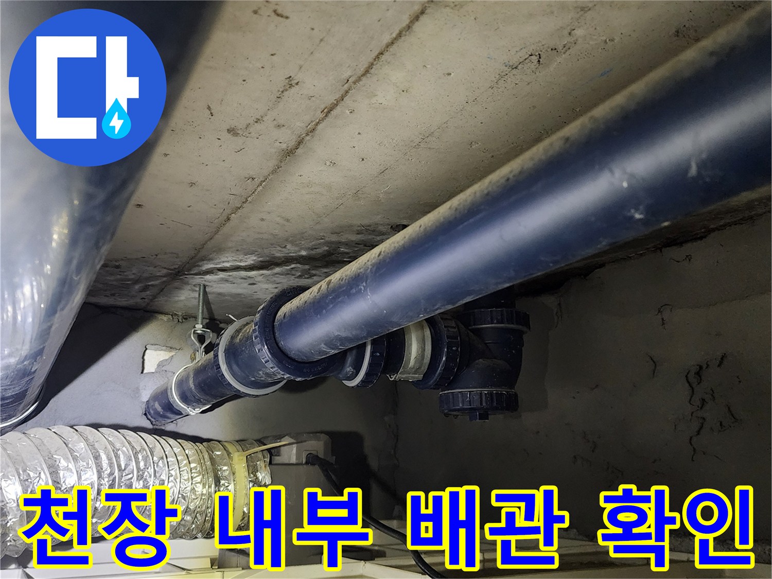 천장 구조물 사이로 보이는 검은색 배관과 연결 부속품들