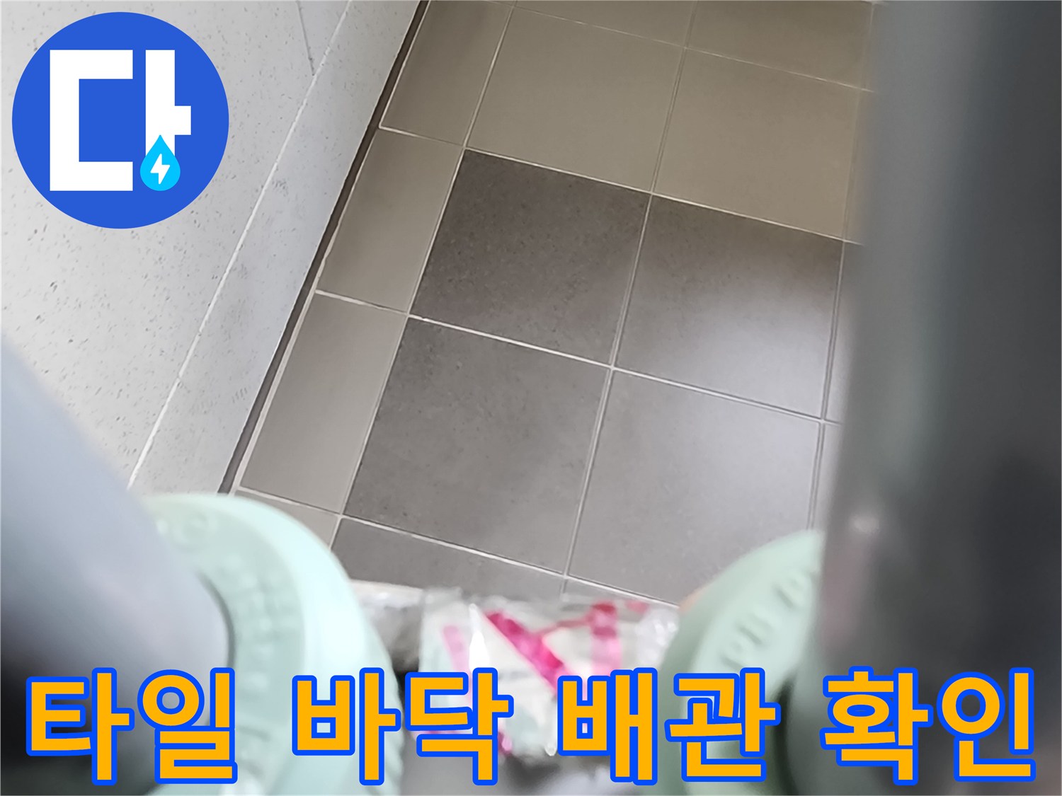 싱크대 아래-배관 부속과 타일 면의 근접 촬영