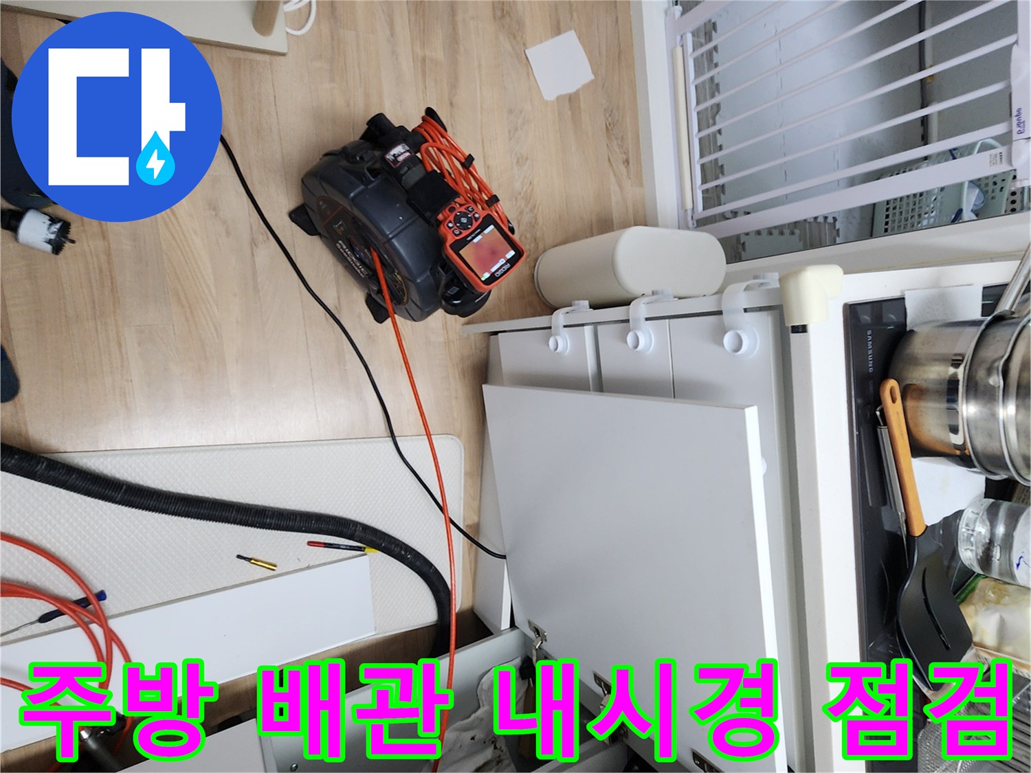 싱크대 하부장 내부에서 진행 중인 배관 내시경 검사 장면