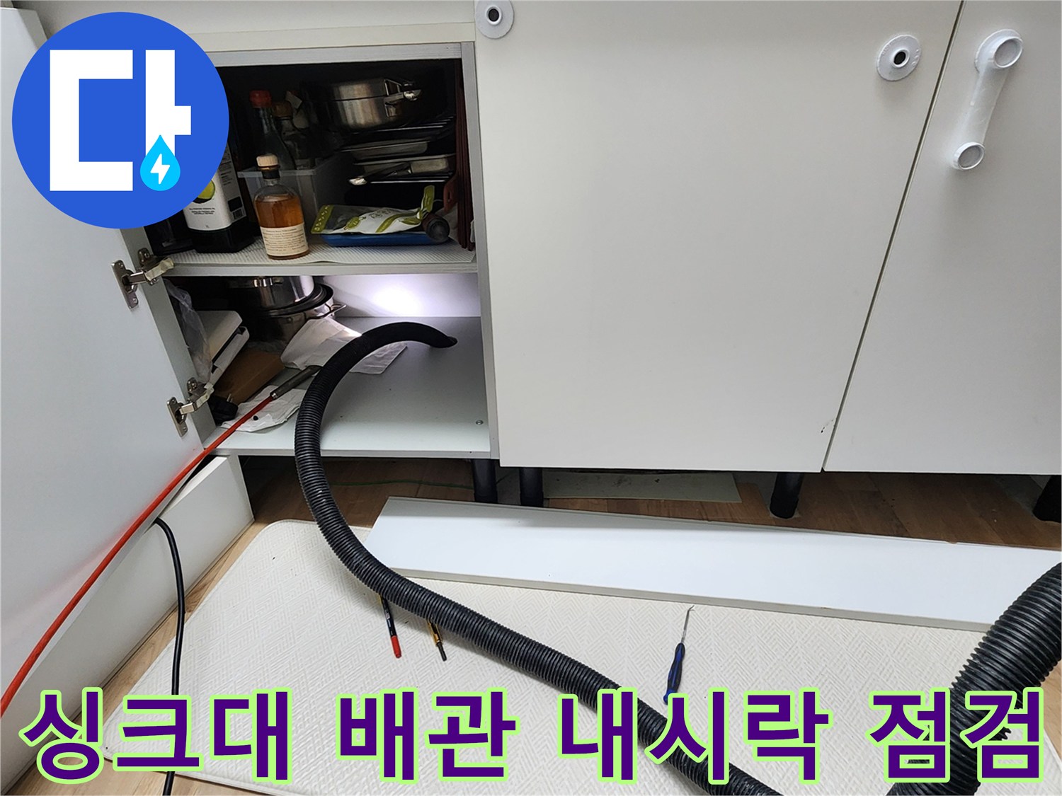 싱크대 하부장 내부의 배관 및 장비 배치 상태