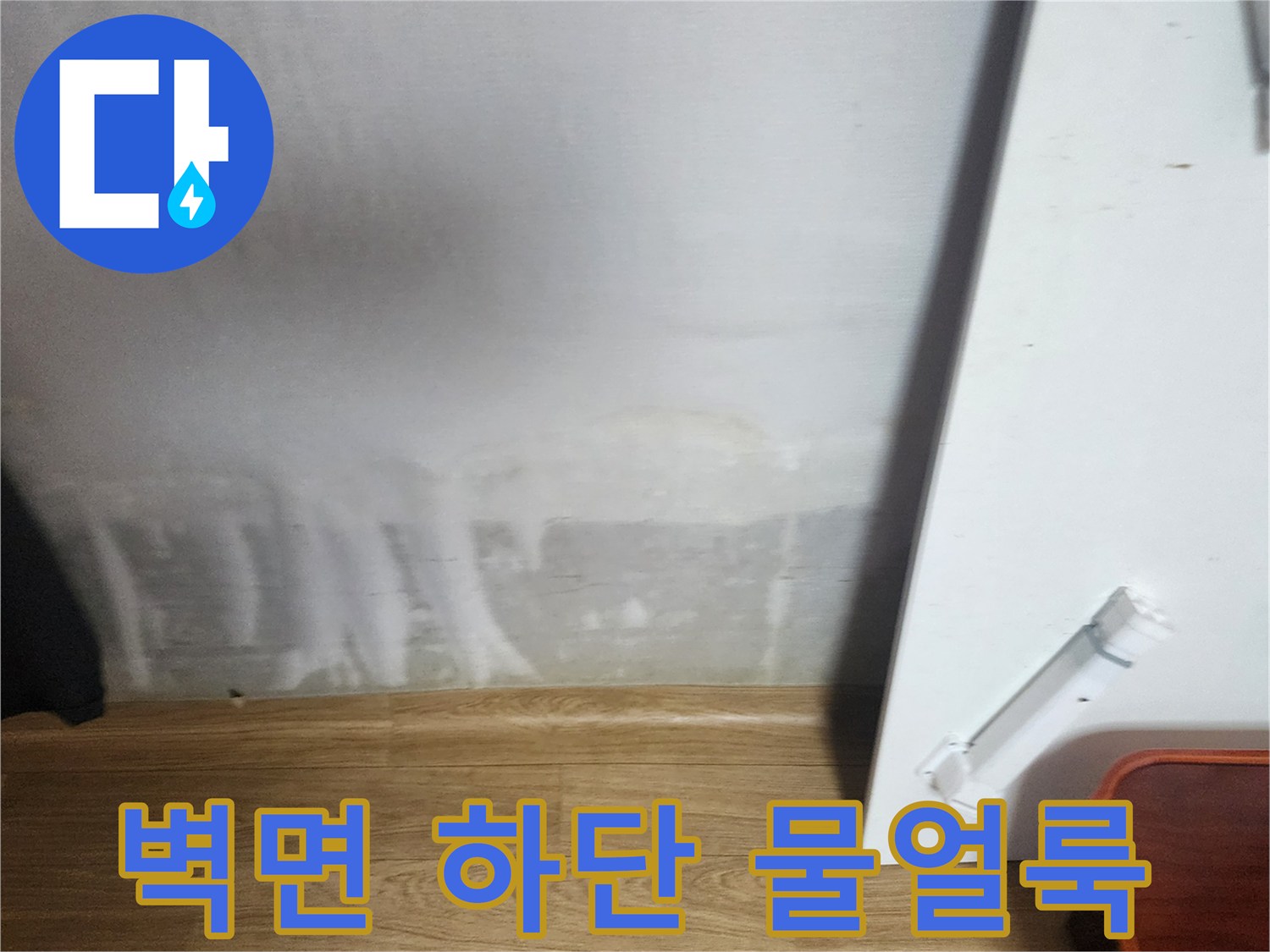 아파트 벽면 하단부에 발생한 하얀색의 심각한 물 얼룩과 습기 흔적