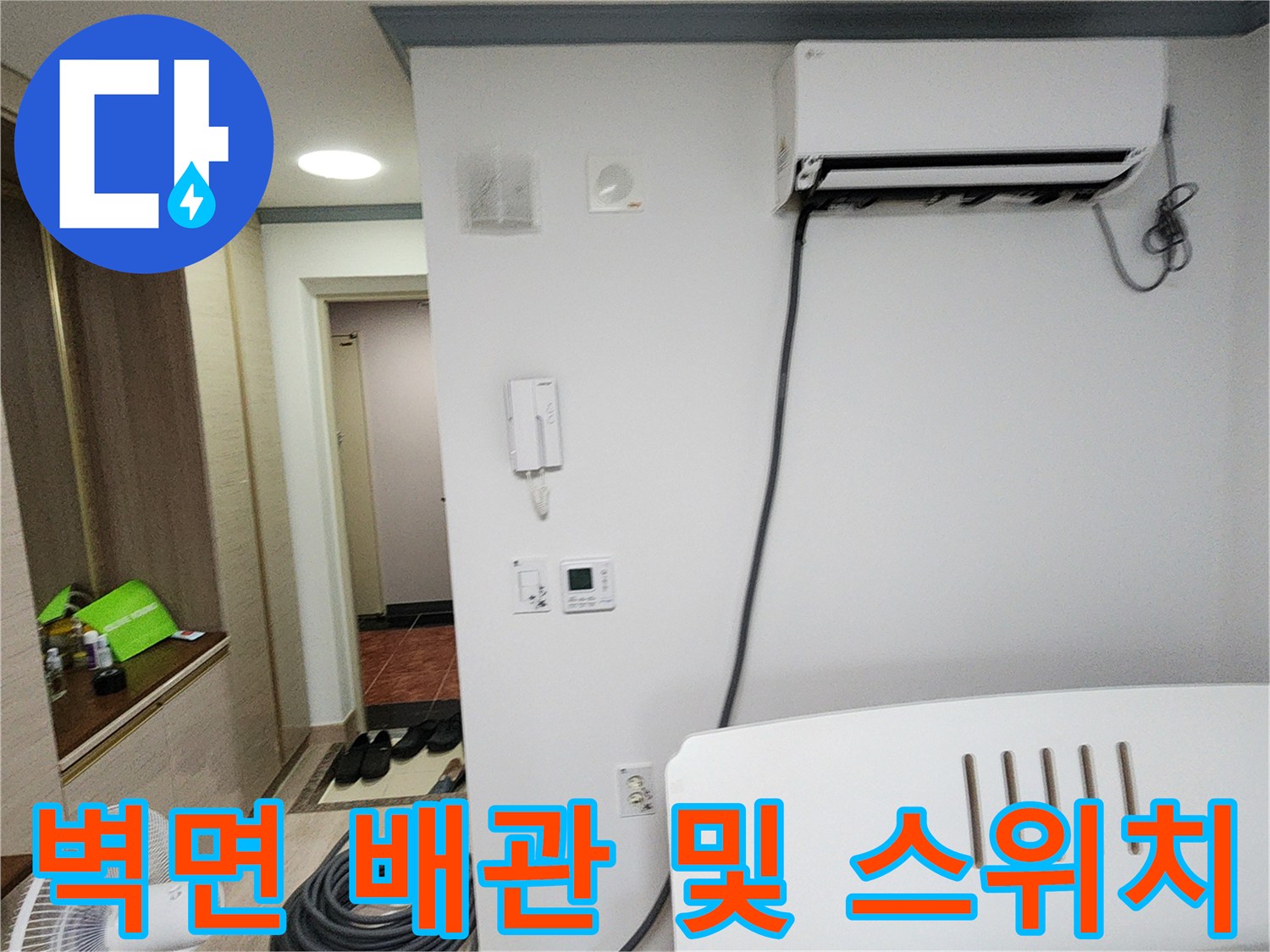 에어컨 배관이 연결된 실내 벽면의 콘센트와 스위치 모습