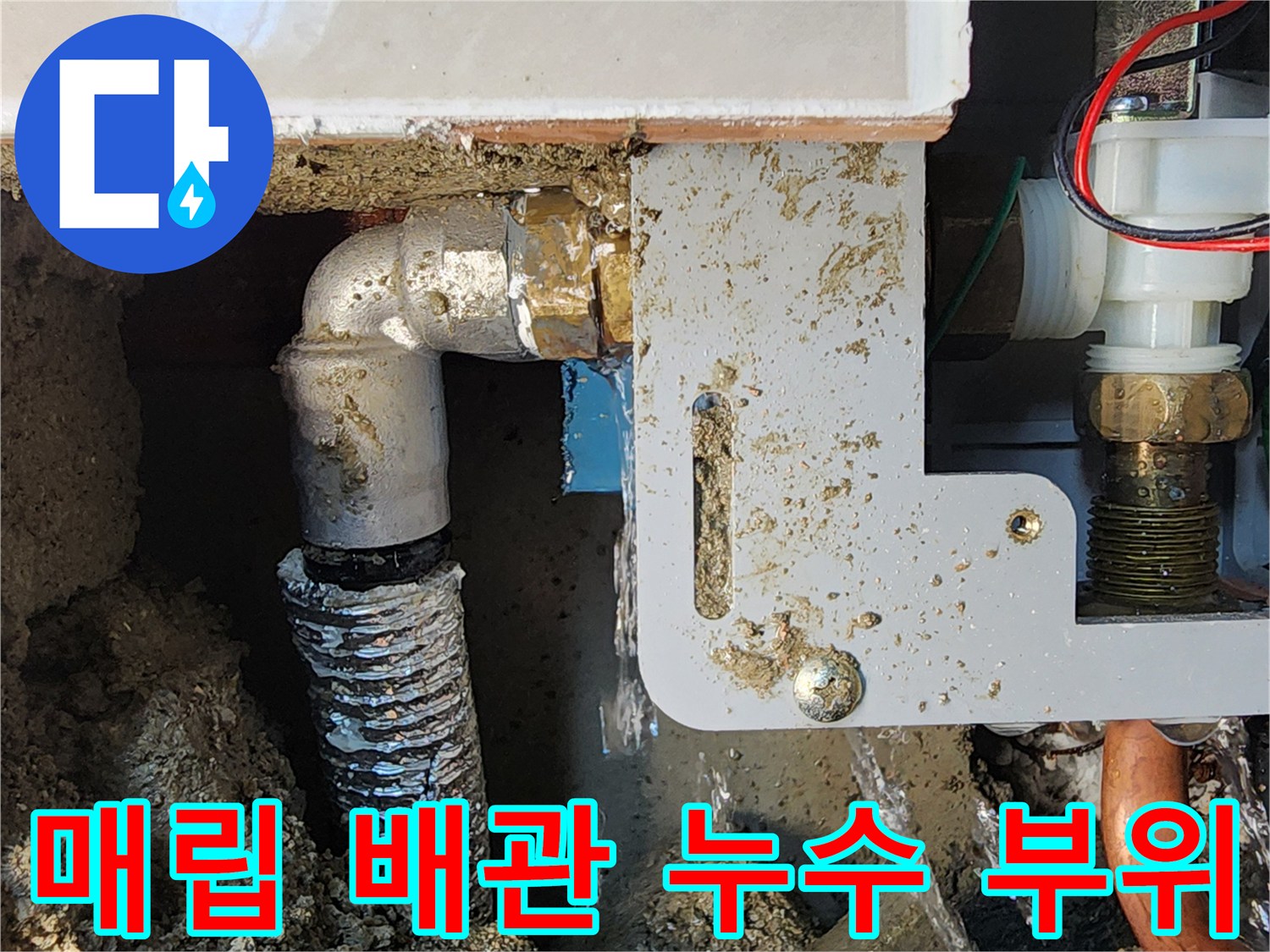 굴착된 벽면 내부의 소변기 급수용 금속 부품과 연결 배관 모습입니다.