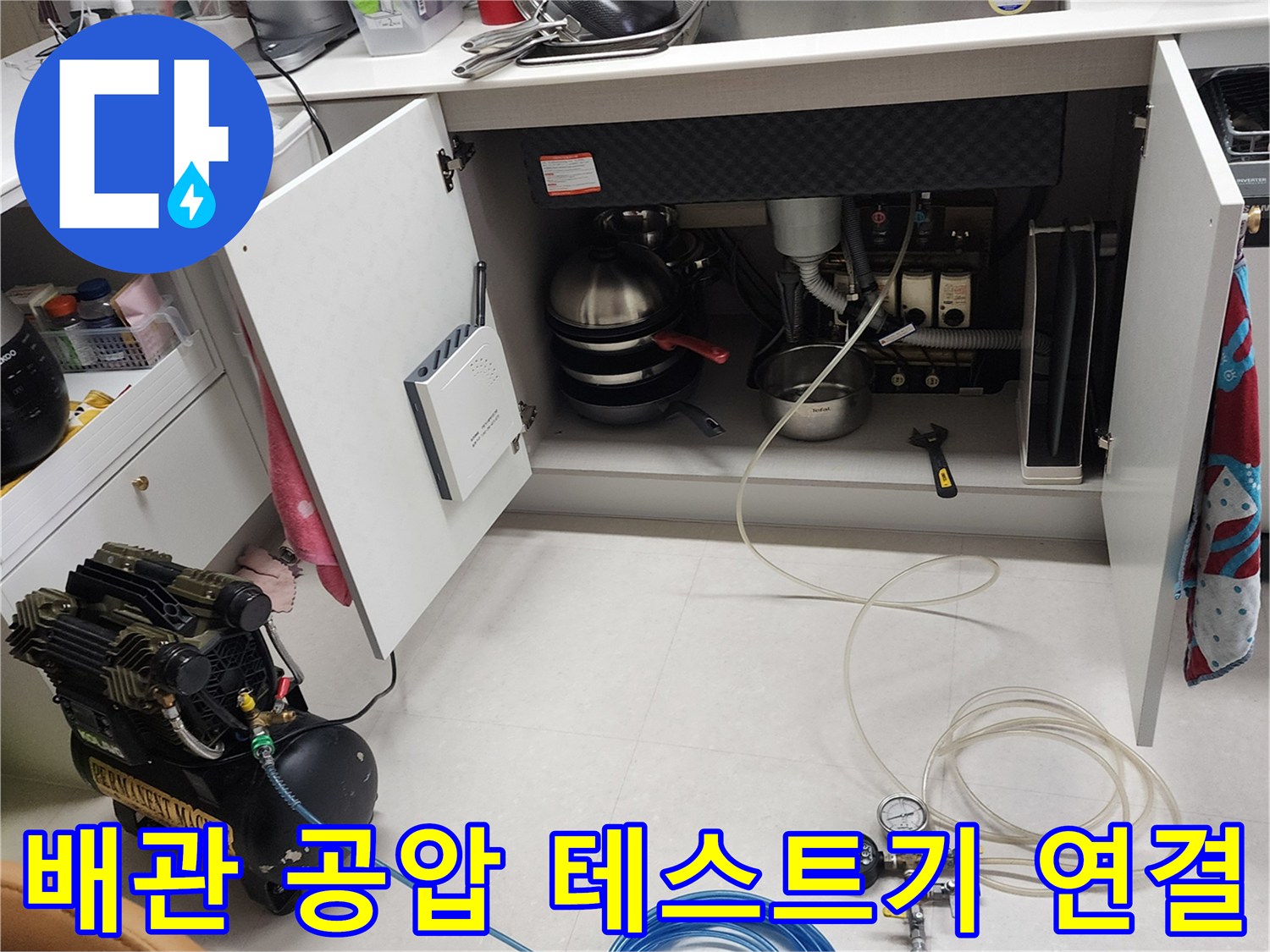공압 테스트기를 사용하여 싱크대 하단 배관의 누수 여부를 정밀하게 측정하는 장면입니다.