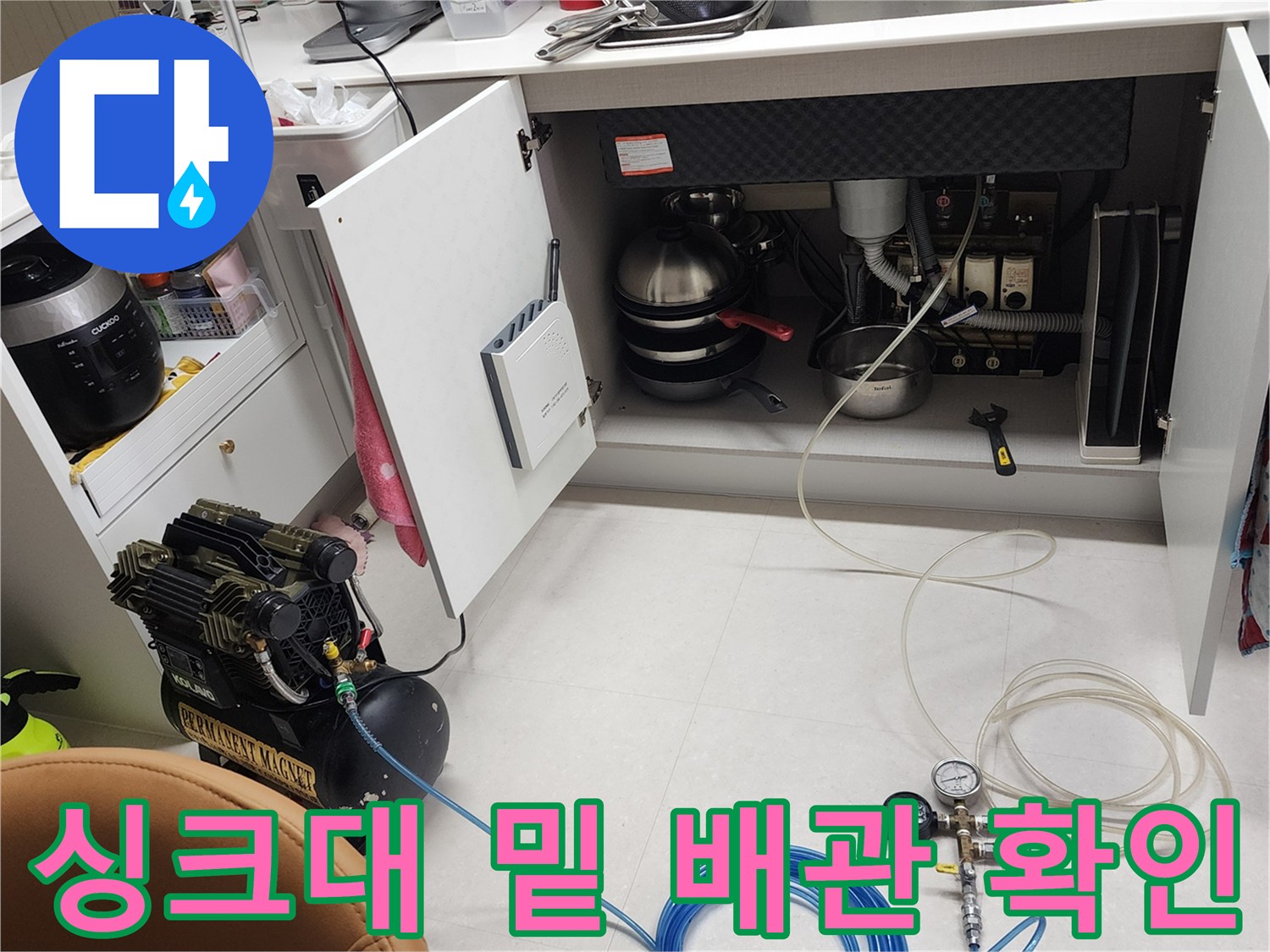 싱크대 하단 공간에 설치된 누수 탐지용 공압 장비와 호스 연결 상태
