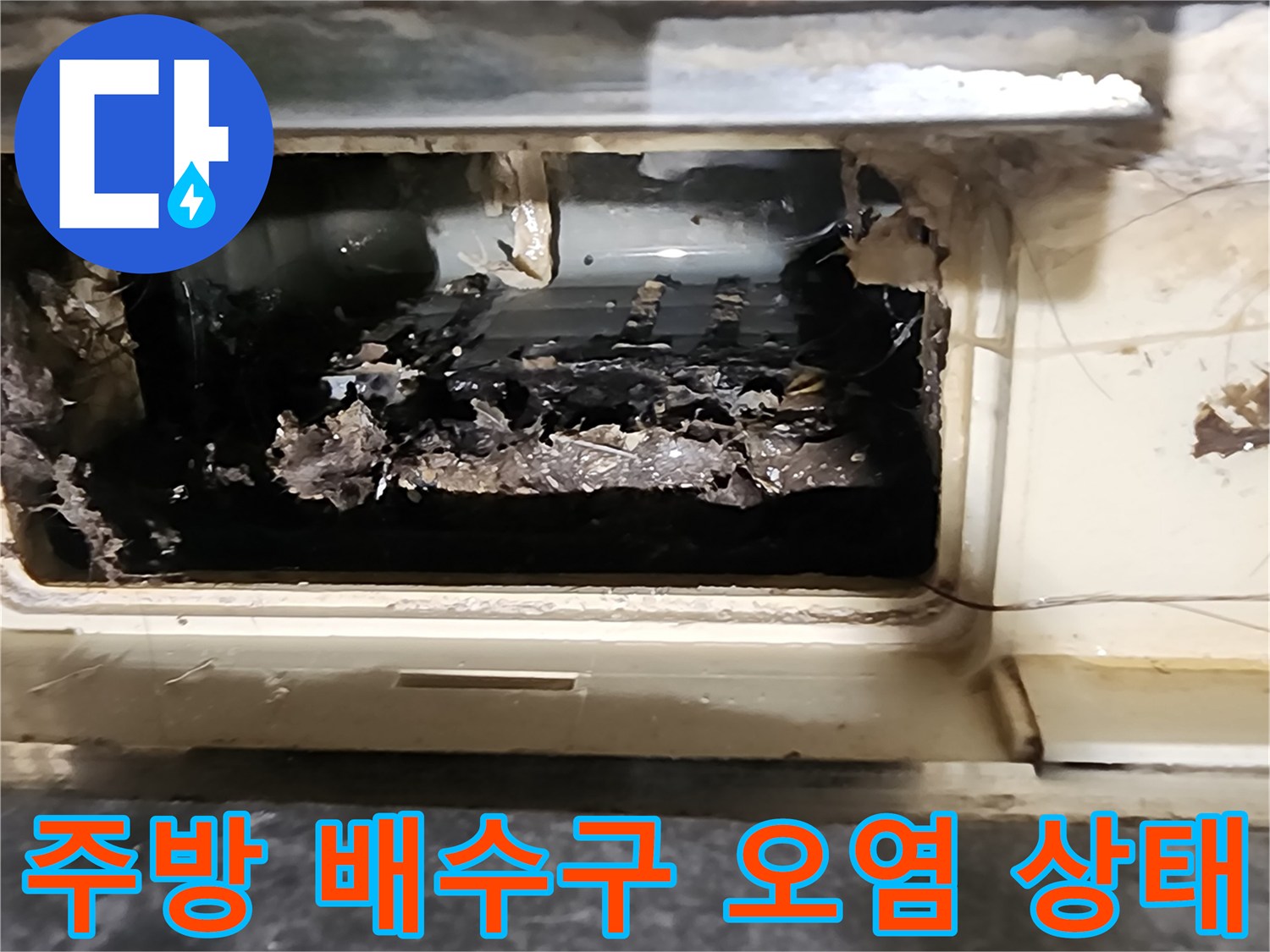 주방 싱크대 하부 배수관 주변에 이물질과 오염이 심각한 상태입니다.