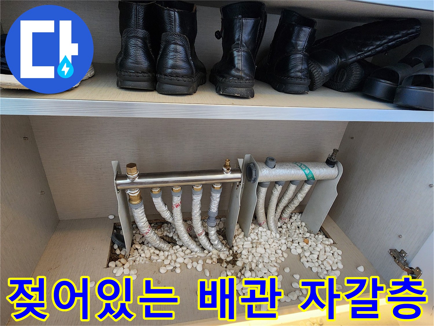 분배기 하단 배관 주변의 젖은 자갈과 보온재 상세 사진