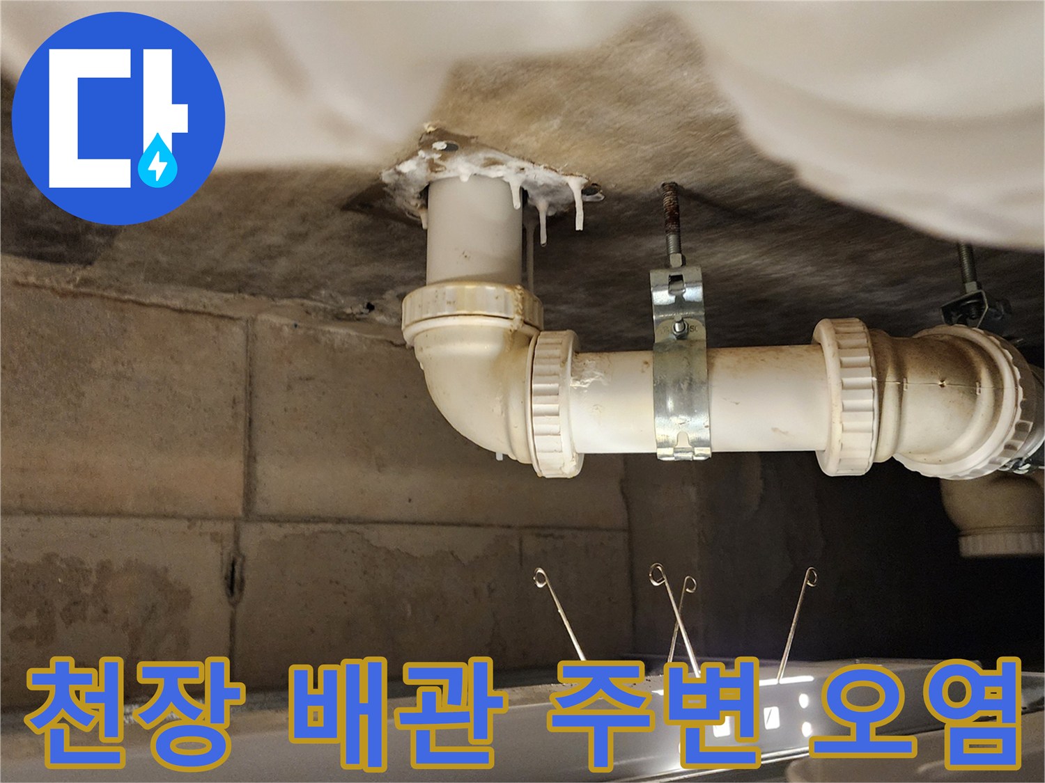 배수 파이프 결속 부위-누수로 인해 발생한 하얀 자국과 습기를 나타냅니다.