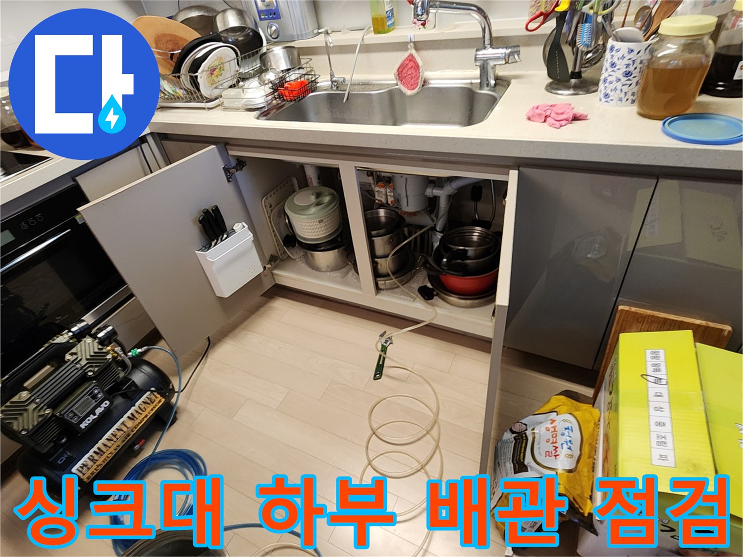 싱크대 아래쪽 배수관과 압력 검사용 장비의 배치 상태