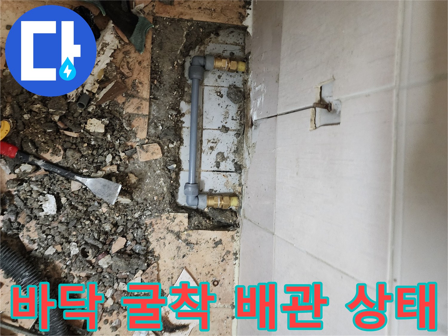 가산면 현장 사진-타일 아래 드러난 손상된 수도 배관 라인