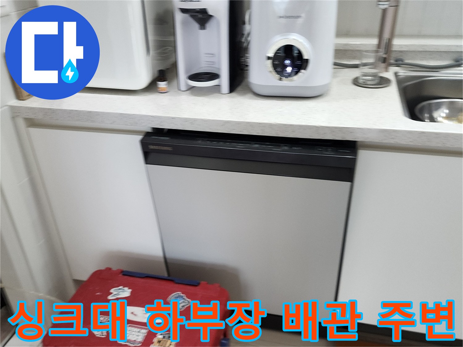 싱크대 아래쪽 가전제품과 하부장 내부 공간을 촬영한 사진입니다.