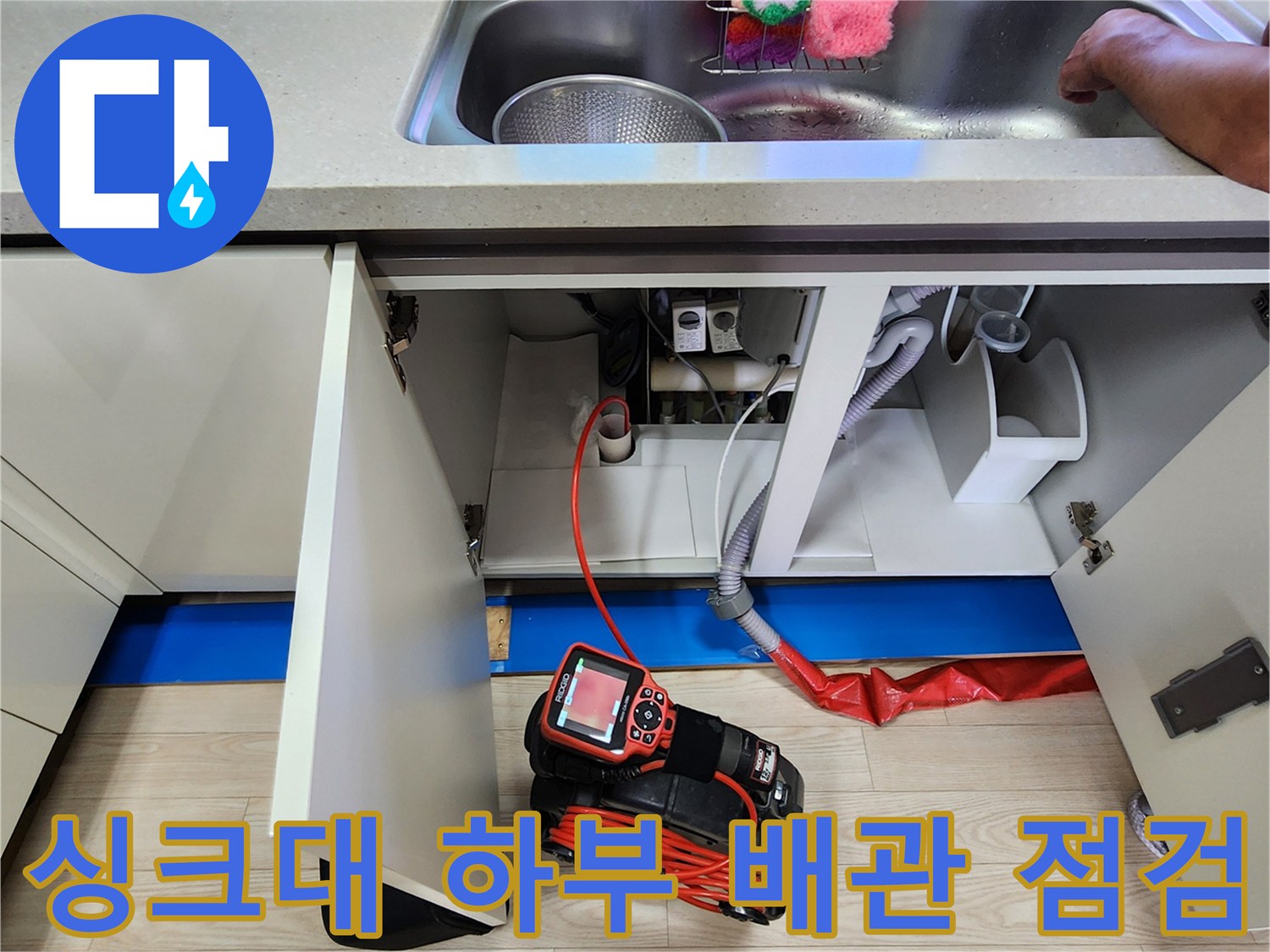 주방 싱크대 하단 배관 상태를 확인하기 위해 전문 탐지 장비를 배치한 모습입니다.