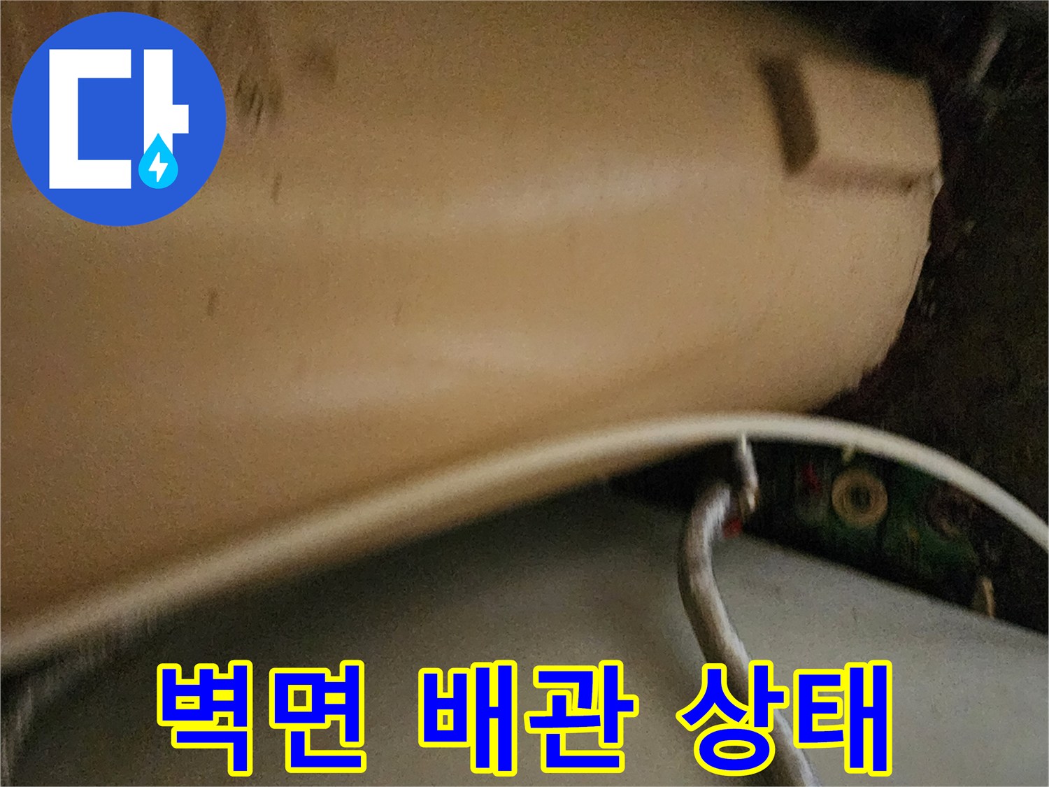 벽면에 설치된 하얀색 배관과 수직 구조물 근접 촬영