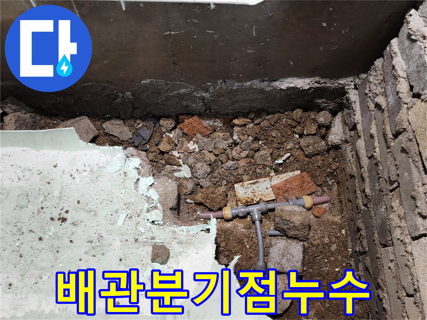 흙과 파편 사이에서 발견된 누수 발생 T자형 배관 부속