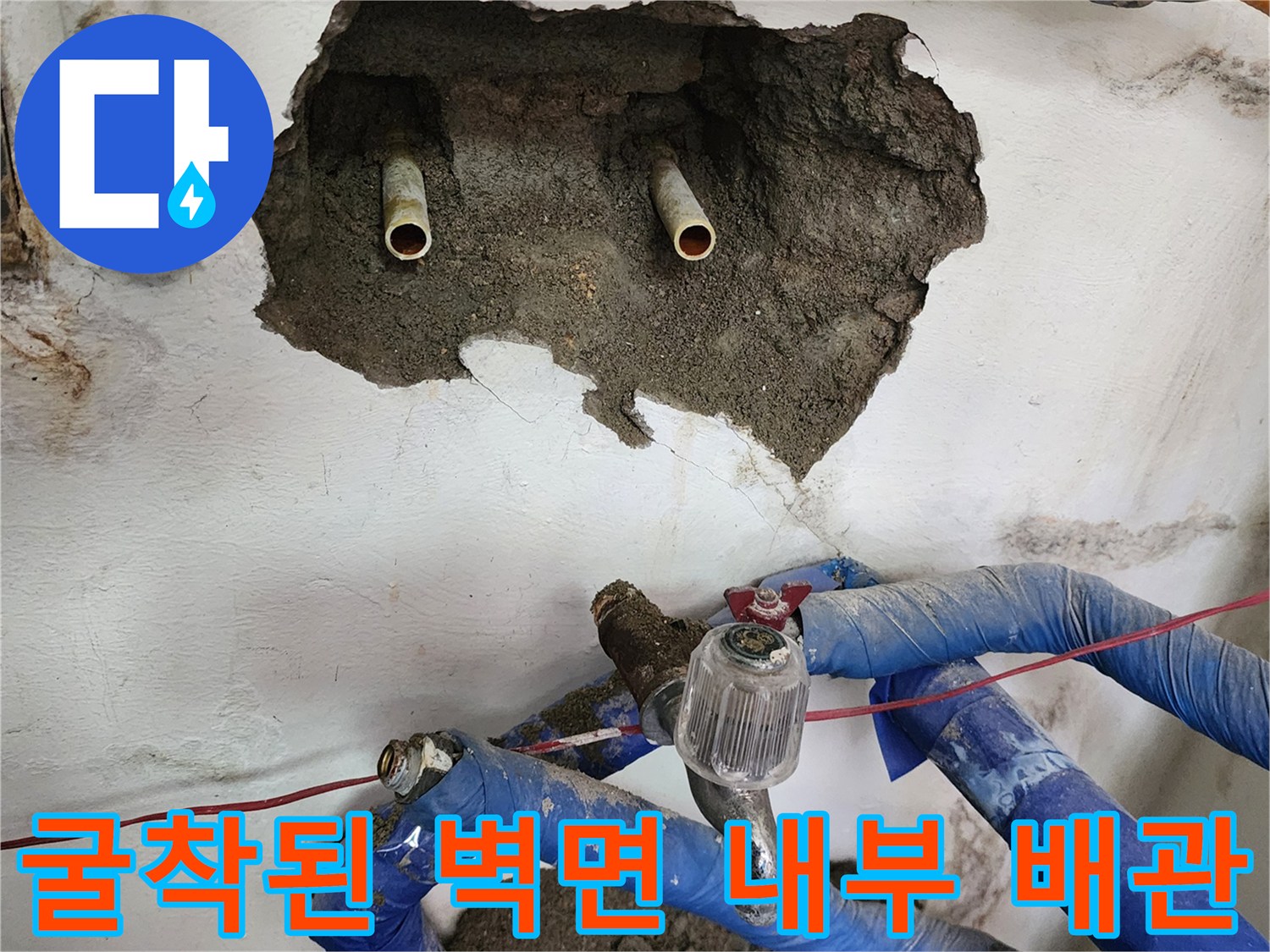누수 지점을 찾기 위해 굴착한 벽면 속 금속 배관