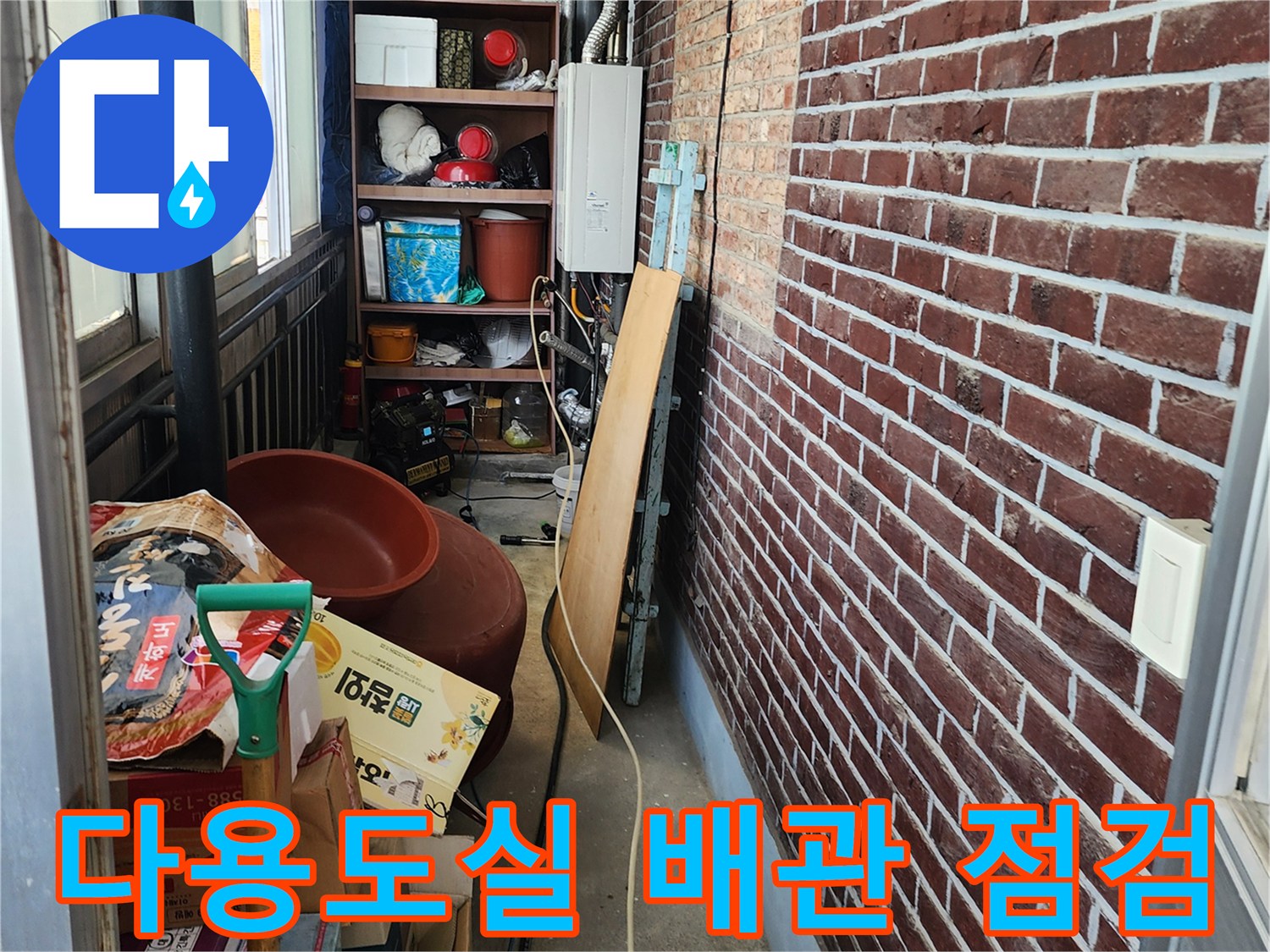 다용도실 내부의 노출된 배관과 벽돌 벽면의 상태를 촬영한 사진입니다.
