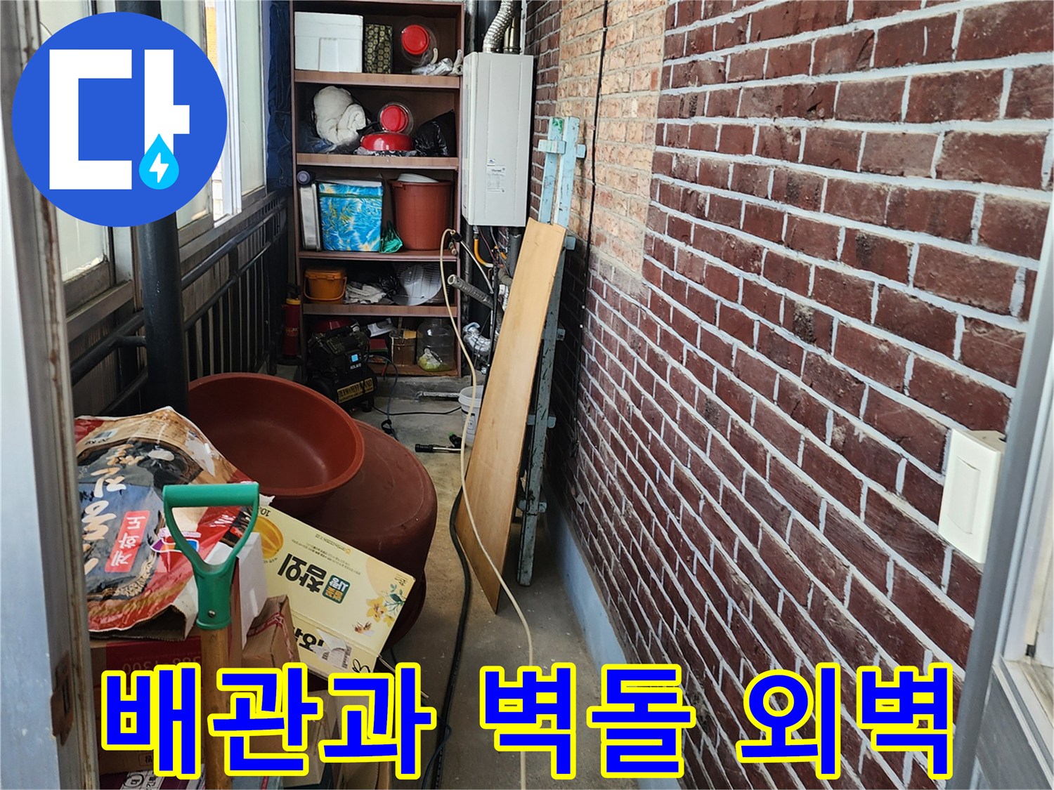다용도실 내부의 배관 구조와 외부로 연결된 벽돌 벽면을 촬영했습니다.