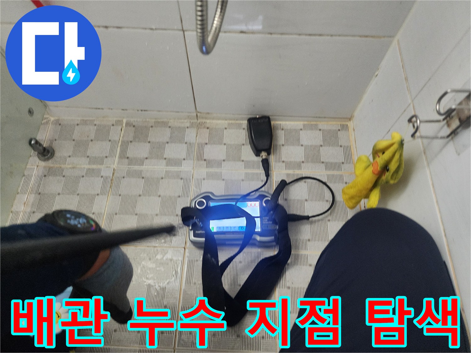 바닥 타일 위 가스식 탐지기와 청음 장비를 배치하여 누수 위치를 찾는 장면
