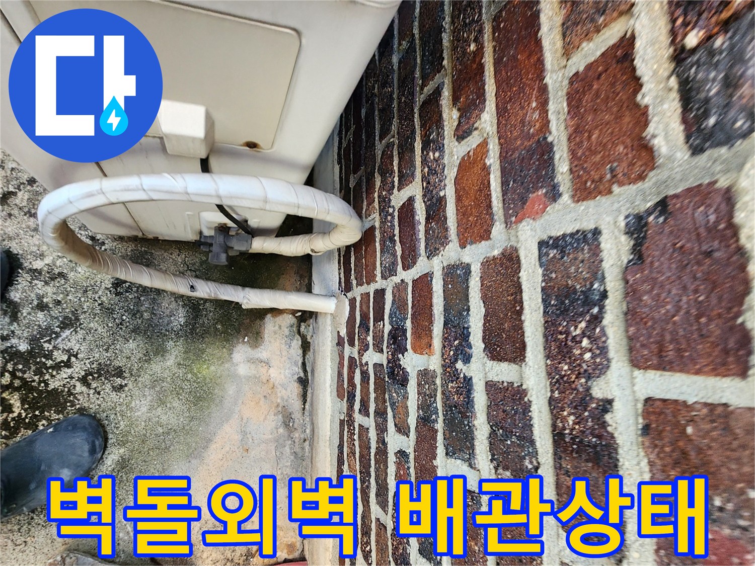 붉은색 벽돌 외벽과 연결된 에어컨 배관의 노후 상태