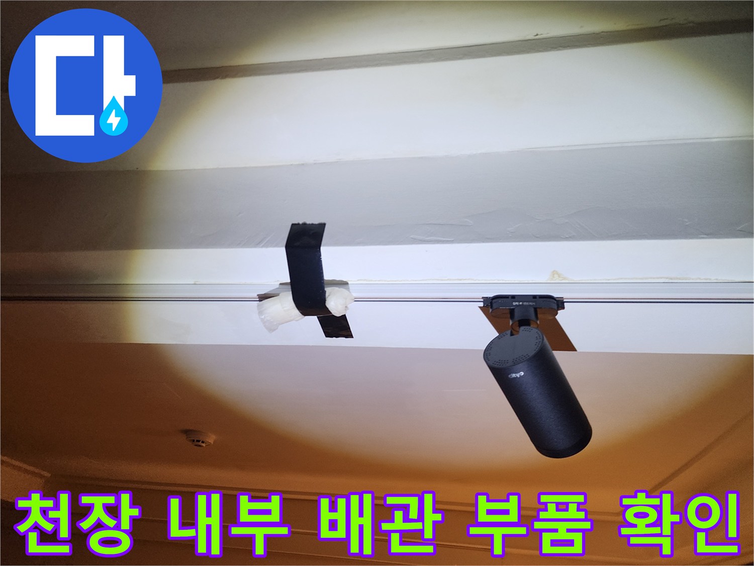 천장 구조물 사이로 보이는 검은색 배관 부속과 연결 장치