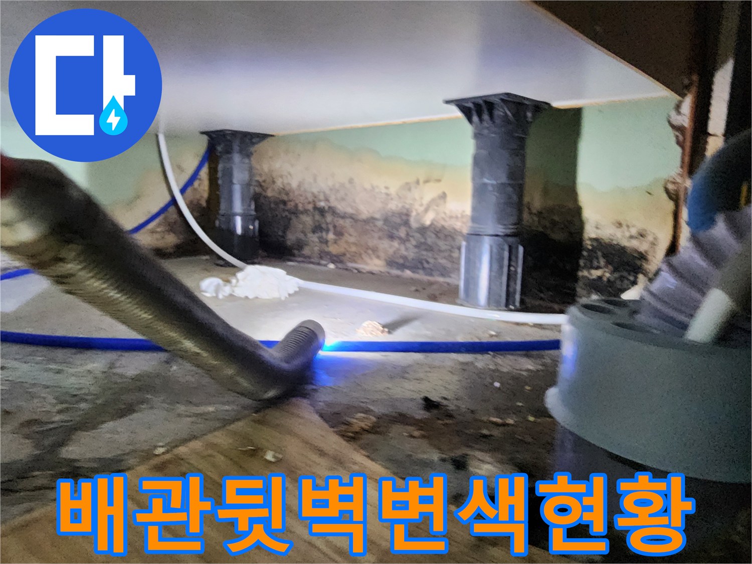 배관 뒤쪽 벽면의 심한 변색과 곰팡이 발생 부위를 보여주는 사진입니다.