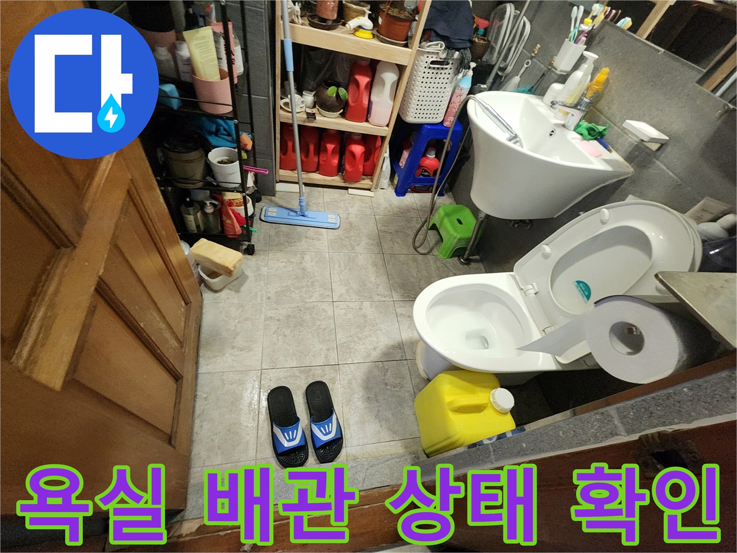 변기와 세면대가 설치된 욕실 바닥의 배수 시설 점검 사진