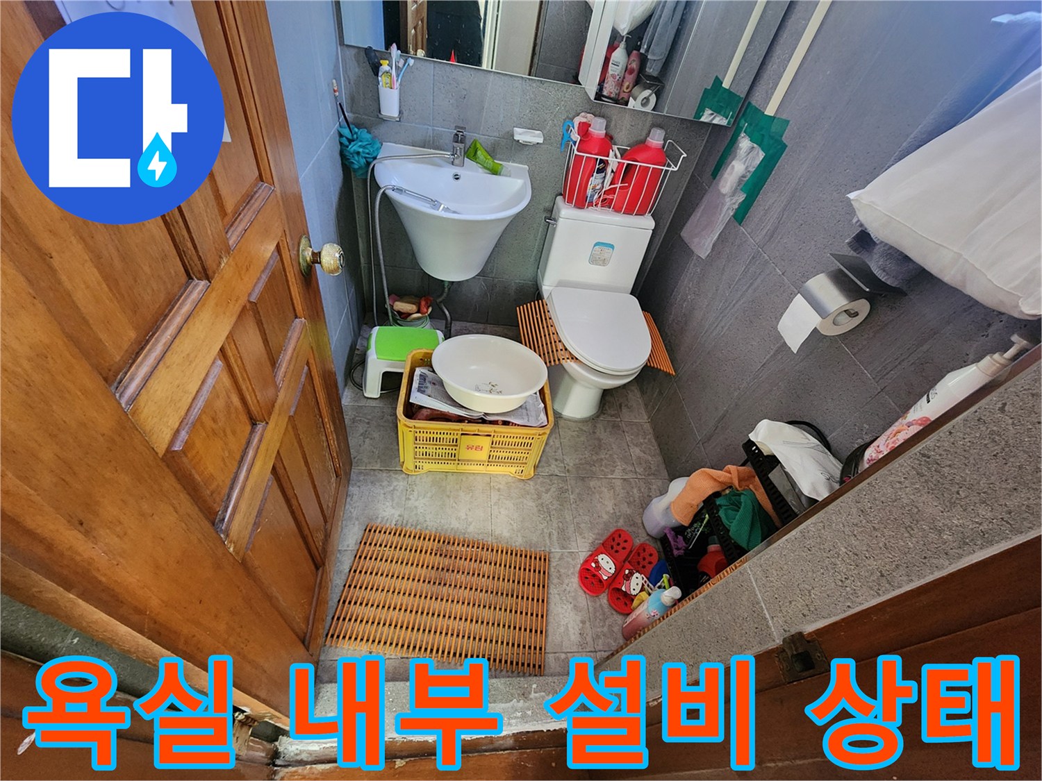 세면대와 변기 그리고 바닥 용품들이 배치된 화장실 현장 사진입니다.