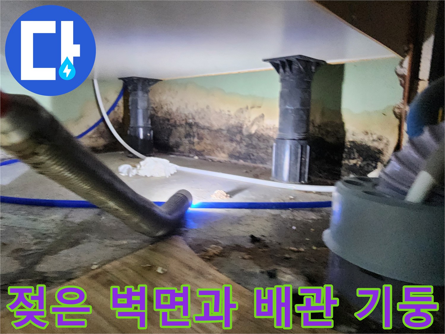 습기로 젖어 어둡게 변한 배관 주변 벽면의 현장 사진