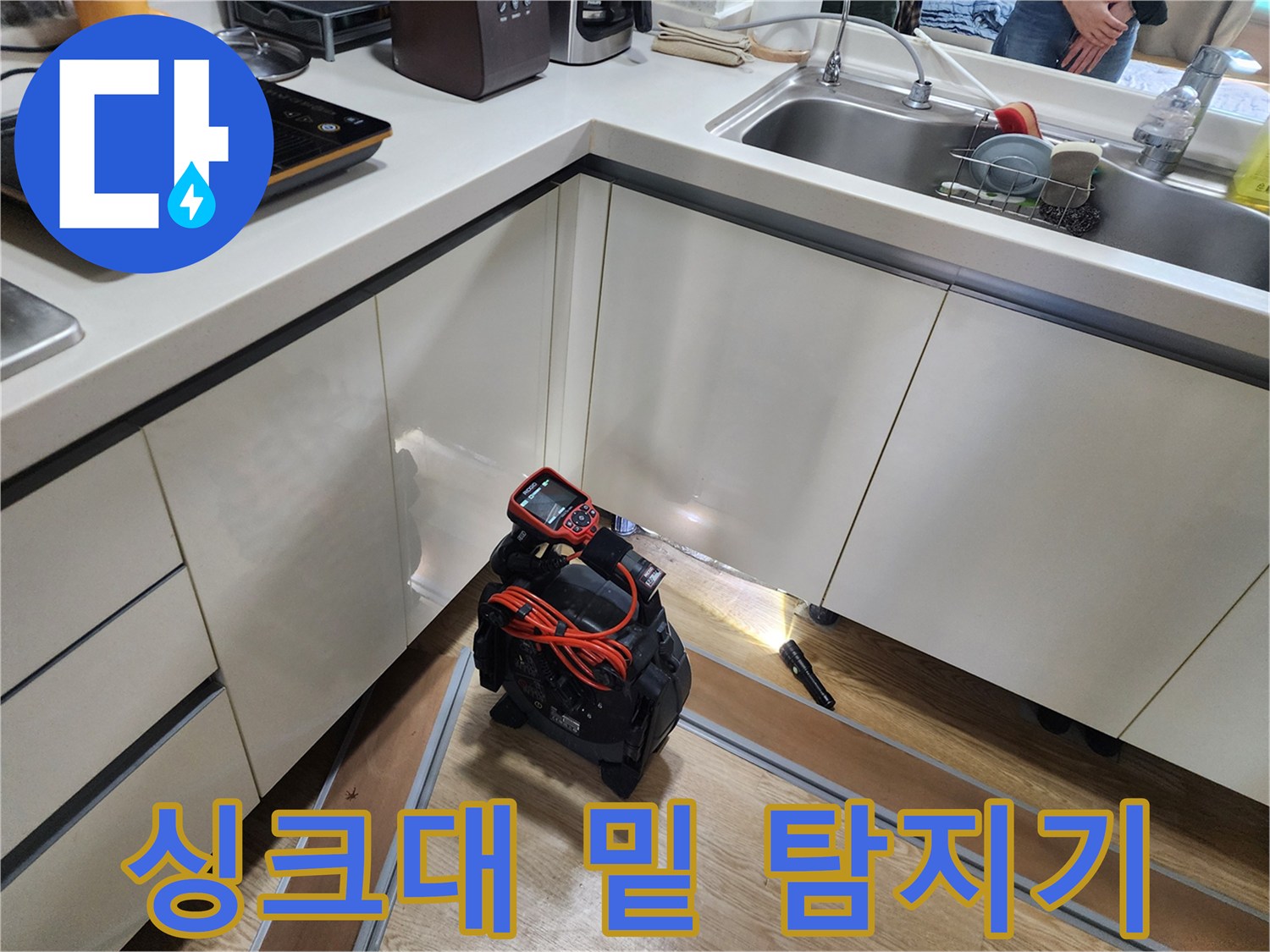 싱크대 아래 공간에 놓인 배관 누수 진단 장비
