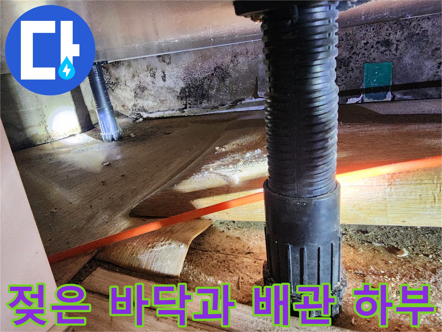 배관 주변의 젖어 있는 콘크리트 슬래브와 오염된 벽면 사진