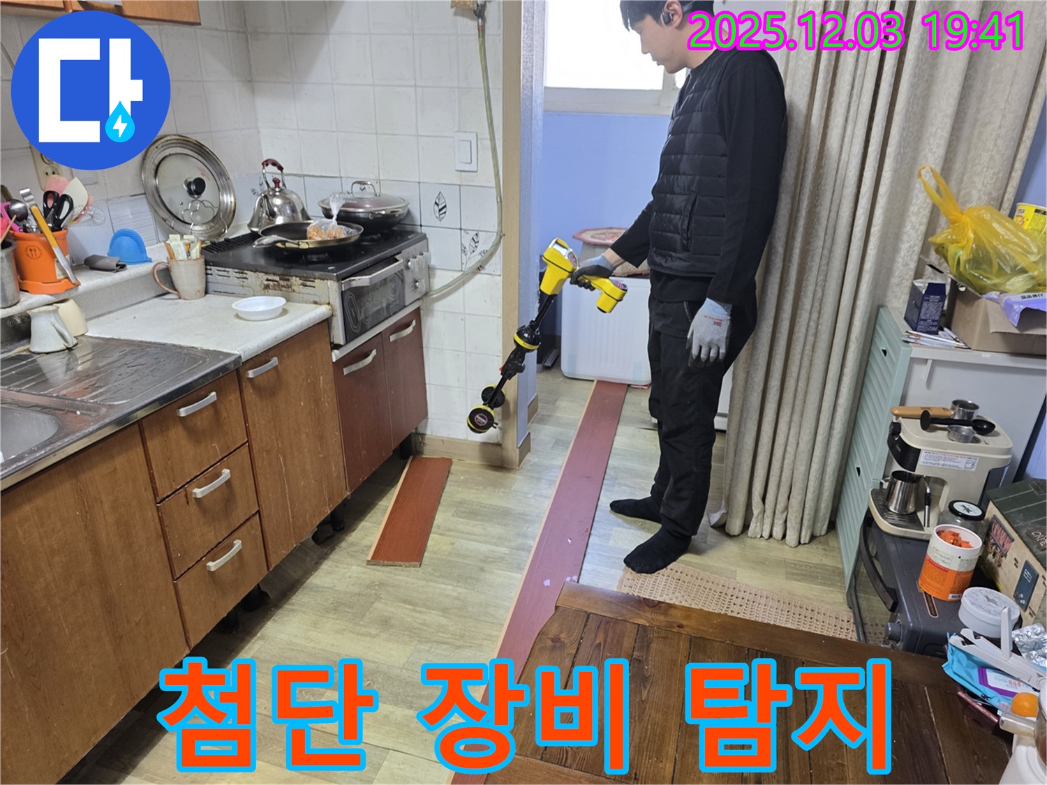 안양 프라자아파트에서 누수탐지 전문가가 첨단 장비를 이용하여 누수 지점을 탐색하는 모습 - 숙련된 기술과 첨단 장비의 완벽한 조화
