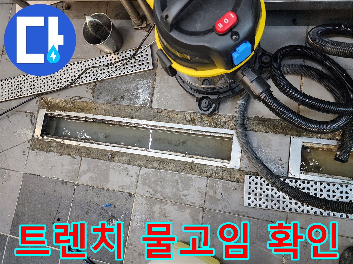 물이 고인 트렌치 주변에 놓인 산업용 진공 청소기