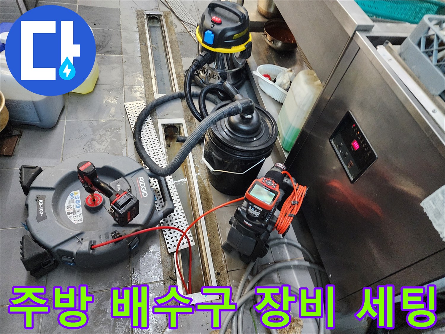 식당 주방 트렌치 주변에 배치된 배관 내시경 카메라와 전동 스프링 및 습식 청소기 작업 준비 상태입니다.